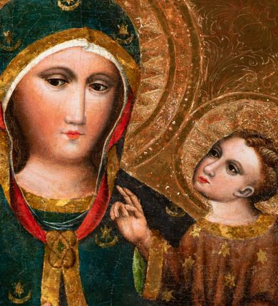 Zdjęcie nr 5: Obraz w kształcie stojącego prostokąta. W centrum kompozycji Matka Boska w typie Hodegetrii ukazana w półpostaci, frontalnie z Dzieciątkiem Jezus na lewym reku, prawą na nie wskazująca. Twarz Marii pociągła, z długim nosem, małymi ustami, ciemnobrązowymi oczami o ciemnej karnacji z zarumienionymi policzkami. Matka Boska ubrana jest w czerwoną suknię ze złotą lamówką przy szyi oraz niebieski płaszcz z motywami kwiatowymi i złotą lamówką na brzegu, zarzucony na ramiona i głowę, zawiązany na piersi wstążką w kokardkę. Dzieciątko ukazane w całej postaci, zwrócone trzy czwarte w prawo, lewą ręką podtrzymuje złotą księgę, prawą unosi na wysokości piersi w geście błogosławieństwa. Twarz okrągła z długim nosem, wąskimi ustami, półprzymkniętymi oczami, okolona krótkimi i brązowymi włosami. Jezus ubrany jest w szarą suknię z długimi rękawami, zdobioną żółto-niebieskim ornamentem kwiatowym oraz złote sandały. Głowy obu postaci ujmują złocone promieniste nimby, otoczone złotym okręgiem. Na głowie Marii i Dzieciątka złote korony: korona Dzieciątka zamknięta, korona Marii widoczna do połowy. Tło złote, ryte w ornamenty roślinne. Rama podwójna: wewnętrzna złocona i profilowana, a zewnętrzna ozdobiona rzeźbioną dekoracją roślinną na czerwonym tle, na brzegach złocona i profilowana.