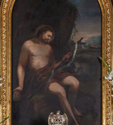 Zdjęcie nr 1: Obraz w kształcie stojącego prostokąta zamkniętego łukiem półkolistym z przedstawieniem św. Jana Chrzciciela. W centrum kompozycji ukazany święty siedzący na skale, zwrócony trzy czwarte w lewo, z prawą stopą wysuniętą do przodu, w lewej ręce trzyma krzyż, a prawą ma odwiedzioną na bok, głowę zwraca w lewą stronę, w kierunku krzyża. Twarz widoczna z prawego profilu, okolona krótką brodą, ze spiczastym nosem; włosy długie, ciemnobrązowe, opadające na plecy. Święty ubrany jest 
 w brązową szatę odsłaniającą nagi tors i nogi. Krzyż długi, opleciony białą banderolą z napisem „ECCE AGNUS DEI”. Po lewej stronie świętego siedzi baranek. W oddali, po prawej stronie obrazu widoczne miasto i pejzaż górski, nad świętym wysoka brązowa skała. Obraz umieszczony jest w złoconej, drewnianej ramie, zdobionej rzędem stylizowanych listków akantu na czerwonym tle.




