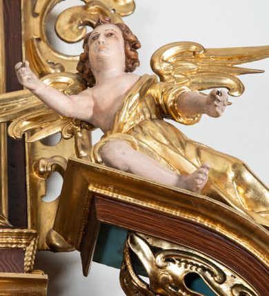 Zdjęcie nr 24: Ołtarz architektoniczny, dwukondygnacyjny, jednoosiowy ze zwieńczeniem. Mensa prostopadłościenna, antepedium w kształcie leżącego prostokąta, flankowane dwoma kanelowanymi pilastrami. W polu, w złoconej ramie dwie połączone płyciny w kształcie stojącego prostokąta wypełnione symetryczną dekoracją z akantu na błękitnym tle. Tabernakulum w formie prostopadłościennej, marmurowej skrzynki, zamknięte od góry prostym, złoconym gzymsem. Ścianka frontowa i drzwiczki obwiedzione złoconymi listwami, w polu łaciński krzyż. Cokół nastawy ustawiony na jednym stopniu, pośrodku zdobiony płyciną w kształcie leżącego prostokąta o zaokrąglonych krótszych bokach, imposty dekorowane mniejszymi płycinami wypełnionymi dekoracją roślinną. Pierwsza kondygnacja ujęta parą kolumn dźwigających przerwane belkowanie z przyczółkami, po bokach dodatkowo flankowana uszami wykończonymi ornamentem małżowinowo-chrząstkowym. W polu głównym obraz Matki Boskiej Szkaplerznej oraz św. Józefa z Dzieciątkiem i ze św. Janem Chrzcicielem na zasuwie, nad nimi para, małych uskrzydlonych aniołków. Po bokach nastawy dwie rzeźby: po prawej św. Katarzyna Aleksandryjska, a po lewej św. Barbara. Na przyczółkach usadzone dwie rzeźby aniołów z rozłożonymi szeroko rękami. Kolumny ustawione na tle prostokątnych płycin, z bazami, trzony gładkie, kapitele kompozytowe. Druga kondygnacja flankowana parą kolumn podtrzymujących wyłamane belkowanie. W polu, w ramie o kształcie stojącego prostokąta o ściętych narożach obraz św. Katarzyny Aleksandryjskiej. W zwieńczeniu promienista gloria z monogramem Marii na błękitnym tle, obwiedzionym wieńcem z obłoków. Struktura malowana w kolorze naturalnego drewna, ornamentyka złocona, detale srebrzone i błękitne.

