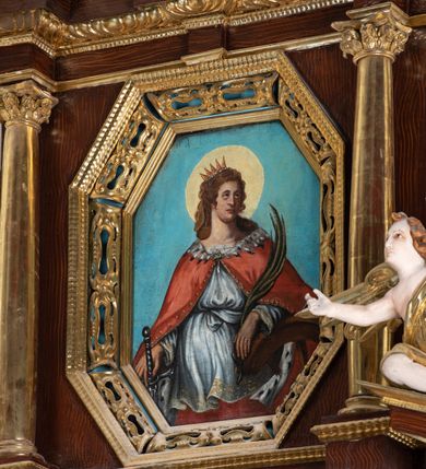 Zdjęcie nr 16: Ołtarz architektoniczny, dwukondygnacyjny, jednoosiowy ze zwieńczeniem. Mensa prostopadłościenna, antepedium w kształcie leżącego prostokąta, flankowane dwoma kanelowanymi pilastrami. W polu, w złoconej ramie dwie połączone płyciny w kształcie stojącego prostokąta wypełnione symetryczną dekoracją z akantu na błękitnym tle. Tabernakulum w formie prostopadłościennej, marmurowej skrzynki, zamknięte od góry prostym, złoconym gzymsem. Ścianka frontowa i drzwiczki obwiedzione złoconymi listwami, w polu łaciński krzyż. Cokół nastawy ustawiony na jednym stopniu, pośrodku zdobiony płyciną w kształcie leżącego prostokąta o zaokrąglonych krótszych bokach, imposty dekorowane mniejszymi płycinami wypełnionymi dekoracją roślinną. Pierwsza kondygnacja ujęta parą kolumn dźwigających przerwane belkowanie z przyczółkami, po bokach dodatkowo flankowana uszami wykończonymi ornamentem małżowinowo-chrząstkowym. W polu głównym obraz Matki Boskiej Szkaplerznej oraz św. Józefa z Dzieciątkiem i ze św. Janem Chrzcicielem na zasuwie, nad nimi para, małych uskrzydlonych aniołków. Po bokach nastawy dwie rzeźby: po prawej św. Katarzyna Aleksandryjska, a po lewej św. Barbara. Na przyczółkach usadzone dwie rzeźby aniołów z rozłożonymi szeroko rękami. Kolumny ustawione na tle prostokątnych płycin, z bazami, trzony gładkie, kapitele kompozytowe. Druga kondygnacja flankowana parą kolumn podtrzymujących wyłamane belkowanie. W polu, w ramie o kształcie stojącego prostokąta o ściętych narożach obraz św. Katarzyny Aleksandryjskiej. W zwieńczeniu promienista gloria z monogramem Marii na błękitnym tle, obwiedzionym wieńcem z obłoków. Struktura malowana w kolorze naturalnego drewna, ornamentyka złocona, detale srebrzone i błękitne.

