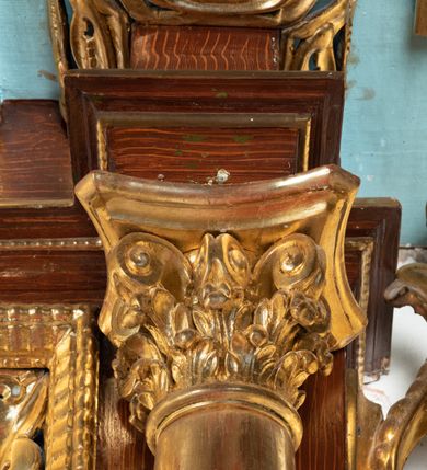 Zdjęcie nr 43: Ołtarz architektoniczny, dwukondygnacyjny, jednoosiowy ze zwieńczeniem. Mensa prostopadłościenna, antepedium w kształcie leżącego prostokąta, flankowane dwoma kanelowanymi pilastrami. W polu, w złoconej ramie dwie połączone płyciny w kształcie stojącego prostokąta wypełnione symetryczną dekoracją z akantu na błękitnym tle. Tabernakulum w formie prostopadłościennej, marmurowej skrzynki, zamknięte od góry prostym, złoconym gzymsem. Ścianka frontowa i drzwiczki obwiedzione złoconymi listwami, w polu łaciński krzyż. Cokół nastawy ustawiony na jednym stopniu, pośrodku zdobiony płyciną w kształcie leżącego prostokąta o zaokrąglonych krótszych bokach, imposty dekorowane mniejszymi płycinami wypełnionymi dekoracją roślinną. Pierwsza kondygnacja ujęta parą kolumn dźwigających przerwane belkowanie z przyczółkami, po bokach dodatkowo flankowana uszami wykończonymi ornamentem małżowinowo-chrząstkowym. W polu głównym obraz Matki Boskiej Szkaplerznej oraz św. Józefa z Dzieciątkiem i ze św. Janem Chrzcicielem na zasuwie, nad nimi para, małych uskrzydlonych aniołków. Po bokach nastawy dwie rzeźby: po prawej św. Katarzyna Aleksandryjska, a po lewej św. Barbara. Na przyczółkach usadzone dwie rzeźby aniołów z rozłożonymi szeroko rękami. Kolumny ustawione na tle prostokątnych płycin, z bazami, trzony gładkie, kapitele kompozytowe. Druga kondygnacja flankowana parą kolumn podtrzymujących wyłamane belkowanie. W polu, w ramie o kształcie stojącego prostokąta o ściętych narożach obraz św. Katarzyny Aleksandryjskiej. W zwieńczeniu promienista gloria z monogramem Marii na błękitnym tle, obwiedzionym wieńcem z obłoków. Struktura malowana w kolorze naturalnego drewna, ornamentyka złocona, detale srebrzone i błękitne.

