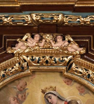 Zdjęcie nr 44: Ołtarz architektoniczny, dwukondygnacyjny, jednoosiowy ze zwieńczeniem. Mensa prostopadłościenna, antepedium w kształcie leżącego prostokąta, flankowane dwoma kanelowanymi pilastrami. W polu, w złoconej ramie dwie połączone płyciny w kształcie stojącego prostokąta wypełnione symetryczną dekoracją z akantu na błękitnym tle. Tabernakulum w formie prostopadłościennej, marmurowej skrzynki, zamknięte od góry prostym, złoconym gzymsem. Ścianka frontowa i drzwiczki obwiedzione złoconymi listwami, w polu łaciński krzyż. Cokół nastawy ustawiony na jednym stopniu, pośrodku zdobiony płyciną w kształcie leżącego prostokąta o zaokrąglonych krótszych bokach, imposty dekorowane mniejszymi płycinami wypełnionymi dekoracją roślinną. Pierwsza kondygnacja ujęta parą kolumn dźwigających przerwane belkowanie z przyczółkami, po bokach dodatkowo flankowana uszami wykończonymi ornamentem małżowinowo-chrząstkowym. W polu głównym obraz Matki Boskiej Szkaplerznej oraz św. Józefa z Dzieciątkiem i ze św. Janem Chrzcicielem na zasuwie, nad nimi para, małych uskrzydlonych aniołków. Po bokach nastawy dwie rzeźby: po prawej św. Katarzyna Aleksandryjska, a po lewej św. Barbara. Na przyczółkach usadzone dwie rzeźby aniołów z rozłożonymi szeroko rękami. Kolumny ustawione na tle prostokątnych płycin, z bazami, trzony gładkie, kapitele kompozytowe. Druga kondygnacja flankowana parą kolumn podtrzymujących wyłamane belkowanie. W polu, w ramie o kształcie stojącego prostokąta o ściętych narożach obraz św. Katarzyny Aleksandryjskiej. W zwieńczeniu promienista gloria z monogramem Marii na błękitnym tle, obwiedzionym wieńcem z obłoków. Struktura malowana w kolorze naturalnego drewna, ornamentyka złocona, detale srebrzone i błękitne.

