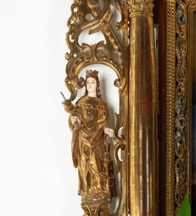 Zdjęcie nr 48: Ołtarz architektoniczny, dwukondygnacyjny, jednoosiowy ze zwieńczeniem. Mensa prostopadłościenna, antepedium w kształcie leżącego prostokąta, flankowane dwoma kanelowanymi pilastrami. W polu, w złoconej ramie dwie połączone płyciny w kształcie stojącego prostokąta wypełnione symetryczną dekoracją z akantu na błękitnym tle. Tabernakulum w formie prostopadłościennej, marmurowej skrzynki, zamknięte od góry prostym, złoconym gzymsem. Ścianka frontowa i drzwiczki obwiedzione złoconymi listwami, w polu łaciński krzyż. Cokół nastawy ustawiony na jednym stopniu, pośrodku zdobiony płyciną w kształcie leżącego prostokąta o zaokrąglonych krótszych bokach, imposty dekorowane mniejszymi płycinami wypełnionymi dekoracją roślinną. Pierwsza kondygnacja ujęta parą kolumn dźwigających przerwane belkowanie z przyczółkami, po bokach dodatkowo flankowana uszami wykończonymi ornamentem małżowinowo-chrząstkowym. W polu głównym obraz Matki Boskiej Szkaplerznej oraz św. Józefa z Dzieciątkiem i ze św. Janem Chrzcicielem na zasuwie, nad nimi para, małych uskrzydlonych aniołków. Po bokach nastawy dwie rzeźby: po prawej św. Katarzyna Aleksandryjska, a po lewej św. Barbara. Na przyczółkach usadzone dwie rzeźby aniołów z rozłożonymi szeroko rękami. Kolumny ustawione na tle prostokątnych płycin, z bazami, trzony gładkie, kapitele kompozytowe. Druga kondygnacja flankowana parą kolumn podtrzymujących wyłamane belkowanie. W polu, w ramie o kształcie stojącego prostokąta o ściętych narożach obraz św. Katarzyny Aleksandryjskiej. W zwieńczeniu promienista gloria z monogramem Marii na błękitnym tle, obwiedzionym wieńcem z obłoków. Struktura malowana w kolorze naturalnego drewna, ornamentyka złocona, detale srebrzone i błękitne.

