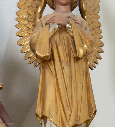 Zdjęcie nr 21: Ołtarz przyścienny, architektoniczny, trójosiowy, jednokondygnacyjny ze zwieńczeniem. Mensa prostopadłościenna. Antepedium trójosiowe, flankowane czterema kolumnami. W osi środkowej płycina w kształcie leżącego prostokąta z monogramem Matki Boskiej w polu i wieńcem z róż. W osiach bocznych płyciny w kształcie stojących prostokątów z bukietem narcyzów w polu. Tabernakulum metalowe w formie prostopadłościennej szafki zamkniętej profilowanym gzymsem wspartym na dwóch smukłych kolumnach. Drzwiczki prostokątne, zamknięte półkoliście z przedstawieniem krzyża z gorejącym sercem w czwórliściu oraz motywem winorośli i kłosów zbóż. Tron wystawienia w formie baldachimu wspartego na czterech smukłych kolumnach, zwieńczonego kopułą i rzeźbą pelikana karmiącego młode. Retabulum ustawione na wysokim cokole i predelli. Nastawa flankowana parą kolumn w części środkowej i parą pilastrów na zewnątrz. Podpory dźwigają wyłamane belkowanie, nad osią środkową wysunięte do przodu i tworzące łuk nadwieszony. W polu głównym, w ramie w kształcie stojącego prostokąta, zamkniętego łukiem półkolistym, umieszczony obraz Matki Boskiej Zembrzyckiej oraz św. Jana Chrzciciela na zasuwie. Nad polem głównym trzy uskrzydlone główki aniołków. W osiach bocznych, w niszach zamkniętych łukiem w ośli grzbiet i zwieńczonych krzyżykiem, ustawione figury świętych: po prawej św. Stanisława, po lewej św. Wojciecha. Zwieńczenie w kształcie cebulastej, ażurowej kopuły, dekorowanej ornamentem roślinnym, spiętej u góry zamkniętą koroną z krzyżykiem. Po bokach zwieńczenia, na osi pilastrów para stojących aniołów. Cokół zdobiony fryzem arkadkowym i zamknięty od góry profilowanym gzymsem. Predella pośrodku dekorowana fryzem arkadowym, a w osiach bocznych stylizowanym ornamentem roślinnym, a na skrajach zawiniętym liściem akantu. Kolumny i pilastry ustawione na bazach, kapitele kompozytowe, trzony kolumn dekorowane ukośną kratką z rozetkami w polu, a trzony pilastrów z płyciną wypełnioną wicią z róż i innych kwiatów. Po bokach ołtarz ujęty ażurowymi uszakami utworzonymi z wolutowo skręconej wici roślinnej. Fryz dekorowany rzędem rozetek. Struktura malowana w kolorze naturalnego drewna, ornamentyka i profilowania złocone, detale czerwone i bordowe, suknie aniołów srebrzone.
