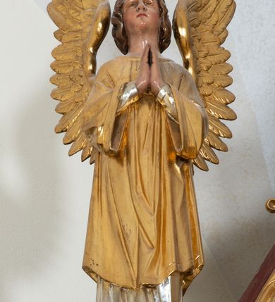 Zdjęcie nr 22: Ołtarz przyścienny, architektoniczny, trójosiowy, jednokondygnacyjny ze zwieńczeniem. Mensa prostopadłościenna. Antepedium trójosiowe, flankowane czterema kolumnami. W osi środkowej płycina w kształcie leżącego prostokąta z monogramem Matki Boskiej w polu i wieńcem z róż. W osiach bocznych płyciny w kształcie stojących prostokątów z bukietem narcyzów w polu. Tabernakulum metalowe w formie prostopadłościennej szafki zamkniętej profilowanym gzymsem wspartym na dwóch smukłych kolumnach. Drzwiczki prostokątne, zamknięte półkoliście z przedstawieniem krzyża z gorejącym sercem w czwórliściu oraz motywem winorośli i kłosów zbóż. Tron wystawienia w formie baldachimu wspartego na czterech smukłych kolumnach, zwieńczonego kopułą i rzeźbą pelikana karmiącego młode. Retabulum ustawione na wysokim cokole i predelli. Nastawa flankowana parą kolumn w części środkowej i parą pilastrów na zewnątrz. Podpory dźwigają wyłamane belkowanie, nad osią środkową wysunięte do przodu i tworzące łuk nadwieszony. W polu głównym, w ramie w kształcie stojącego prostokąta, zamkniętego łukiem półkolistym, umieszczony obraz Matki Boskiej Zembrzyckiej oraz św. Jana Chrzciciela na zasuwie. Nad polem głównym trzy uskrzydlone główki aniołków. W osiach bocznych, w niszach zamkniętych łukiem w ośli grzbiet i zwieńczonych krzyżykiem, ustawione figury świętych: po prawej św. Stanisława, po lewej św. Wojciecha. Zwieńczenie w kształcie cebulastej, ażurowej kopuły, dekorowanej ornamentem roślinnym, spiętej u góry zamkniętą koroną z krzyżykiem. Po bokach zwieńczenia, na osi pilastrów para stojących aniołów. Cokół zdobiony fryzem arkadkowym i zamknięty od góry profilowanym gzymsem. Predella pośrodku dekorowana fryzem arkadowym, a w osiach bocznych stylizowanym ornamentem roślinnym, a na skrajach zawiniętym liściem akantu. Kolumny i pilastry ustawione na bazach, kapitele kompozytowe, trzony kolumn dekorowane ukośną kratką z rozetkami w polu, a trzony pilastrów z płyciną wypełnioną wicią z róż i innych kwiatów. Po bokach ołtarz ujęty ażurowymi uszakami utworzonymi z wolutowo skręconej wici roślinnej. Fryz dekorowany rzędem rozetek. Struktura malowana w kolorze naturalnego drewna, ornamentyka i profilowania złocone, detale czerwone i bordowe, suknie aniołów srebrzone.
