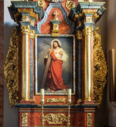 Zdjęcie nr 1: Ołtarz architektoniczny, jednondygnacyjny, jednoosiowy, ze zwieńczeniem. Ołtarz prostopadłościenny, z drewnianą mensą i kamiennym portatylem. Retabulum na niewysokim cokole o zryzalitowanych, uskokowych bokach. Retabulum ujęte parą zdwojonych filarów z przylegającymi do nich od wewnętrznej strony wąskimi pilastrami oraz parą kolumn wspierających przerwane, wyłamujące się po środku belkowanie. Zwieńczenie w formie przerwanego przyczółka w kształcie trójkąta o wklęsłych ramionach. 
Antependium,  pośrodku z motywem płaskorzeźbionego monogramu IHS i gorejącego Serca Jezusa ujętego wieńcem srebrzonych obłoków i promienistą glorią. Powierzchnia boków płyciny antependium pokryta wicią akantową. W polach cokołu dolnej kondygnacji retabulum i w dolnej partii części środkowej retabulum oraz w części belkowania ornamentyka akantowa. W górnej partii części środkowej, po środku niewielki cokolik zdobiony fragmentem wici akantowej zwieńczony półkulą z kwiatonem ujętym parą antytetycznych wolut. Dolna kondygnacja retabulum ujęta parą ażurowych, akantowych uszaków. Boki górnej kondygnacji zdobione motywem ornamentu akantowego. Partie gzymsu z ornamentyką roślinną. Pole części środkowej dolnej kondygnacji w kształcie stojącego prostokąta ujętego srebrzona i złoconą ramą w formie półwałka, zdobioną motywem liści laurowych. W środku obraz Serce Jezusa. W zwieńczeniu  rzeźbione popiersie Boga Ojca. Kondygnacja ta ujęta parą rzeźb św. Jana Chrzciciela po lewej stronie i św. Jana Ewangelisty po prawej. Po środku zwieńczenia figura Archanioła Michała. Na krawędziach przerwanego przyczółka para aniołków przyklękających na srebrzonych obłokach.
Struktura marmoryzowana w odcieniach brązów i szarości. Partie detalu architektonicznego i ornamentyka złocone i srebrzone.         
