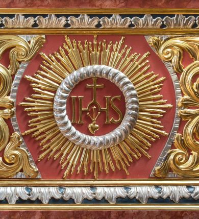 Zdjęcie nr 11: Ołtarz architektoniczny, jednondygnacyjny, jednoosiowy, ze zwieńczeniem. Ołtarz prostopadłościenny, z drewnianą mensą i kamiennym portatylem. Retabulum na niewysokim cokole o zryzalitowanych, uskokowych bokach. Retabulum ujęte parą zdwojonych filarów z przylegającymi do nich od wewnętrznej strony wąskimi pilastrami oraz parą kolumn wspierających przerwane, wyłamujące się po środku belkowanie. Zwieńczenie w formie przerwanego przyczółka w kształcie trójkąta o wklęsłych ramionach. 
Antependium,  pośrodku z motywem płaskorzeźbionego monogramu IHS i gorejącego Serca Jezusa ujętego wieńcem srebrzonych obłoków i promienistą glorią. Powierzchnia boków płyciny antependium pokryta wicią akantową. W polach cokołu dolnej kondygnacji retabulum i w dolnej partii części środkowej retabulum oraz w części belkowania ornamentyka akantowa. W górnej partii części środkowej, po środku niewielki cokolik zdobiony fragmentem wici akantowej zwieńczony półkulą z kwiatonem ujętym parą antytetycznych wolut. Dolna kondygnacja retabulum ujęta parą ażurowych, akantowych uszaków. Boki górnej kondygnacji zdobione motywem ornamentu akantowego. Partie gzymsu z ornamentyką roślinną. Pole części środkowej dolnej kondygnacji w kształcie stojącego prostokąta ujętego srebrzona i złoconą ramą w formie półwałka, zdobioną motywem liści laurowych. W środku obraz Serce Jezusa. W zwieńczeniu  rzeźbione popiersie Boga Ojca. Kondygnacja ta ujęta parą rzeźb św. Jana Chrzciciela po lewej stronie i św. Jana Ewangelisty po prawej. Po środku zwieńczenia figura Archanioła Michała. Na krawędziach przerwanego przyczółka para aniołków przyklękających na srebrzonych obłokach.
Struktura marmoryzowana w odcieniach brązów i szarości. Partie detalu architektonicznego i ornamentyka złocone i srebrzone.         
