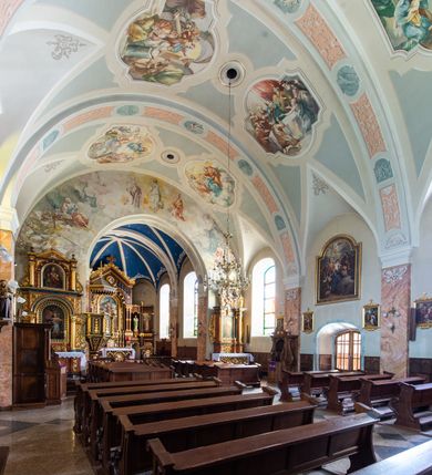 Zdjęcie nr 31: Kościół orientowany, jest budowlą murowaną z cegły i kamienia, na rzucie podłużnym. Korpus nawowy jest jednonawowy i czteroprzęsłowy. Do dwuprzęsłowego, zamkniętego trójbocznie prezbiterium od północy przylega zakrystia. Na osi kościoła, w przedłużeniu północnego przęsła jest czworoboczna, wysunięta przed lico fasady wieża. Od południa do drugiego przęsła korpusu przylega kruchta. Nawa przekryta jest sklepieniem kolebkowym z lunetami wspartymi na pilastrach, w prezbiterium sklepienie krzyżowo-żebrowe z gurtą wspartą na pilastrach. Przestrzeń prezbiterium od korpusu nawowego oddziela półkolista arkada łuku tęczowego i drewniana balustrada. Artykulację ścian na zewnątrz kościoła stanowi zespół dwuuskokowych przypór, w narożach wieży są czterouskokowe, osadzonych na niewysokim cokole. Do wnętrza prowadzą 3 otwory drzwiowe. Dwuskrzydłowe drzwi w fasadzie ujęte są kamiennym obramieniem zamkniętym łukiem koszowym z kluczem pośrodku, wspartym na gzymsie oraz 2 w północnej ścianie kaplicy bocznej. 2 prostokątne prowadzą przez kruchtę i zakrystię. Ściany korpusu nawowego i prezbiterium przeprute są prostokątnymi oknami zamkniętymi łukiem odcinkowym. Okno na zakończeniu prezbiterium jest formie półkoliście zamkniętej niszy z figurą Matki Boskiej. Kształt okien korpusu i prezbiterium został powtórzony w przyległości prezbiterium. Powyżej wejścia na osi wieży małe okienko zamknięte łukiem koszowym, wyżej nisza zamknięta ostrołukowo. W górnej partii wieży znajdują się cztery, duże, zamknięte półkoliście otwory okienne ujęte prostymi obramieniami. Szczyt wierzy obiega gzyms wieńczący z półkolistym łukiem na osi każdej ze ścian. Dach w formie hełmu z latarnią. Dach prezbiterium i korpusu dwuspadowy, kryty blachą, nad pierwszym przęsłem wieżyczka na sygnaturkę. Kruchta z dachem dwuspadowym, przyległość pulpitowym. Tynki w kolorze beżowym i białym. 