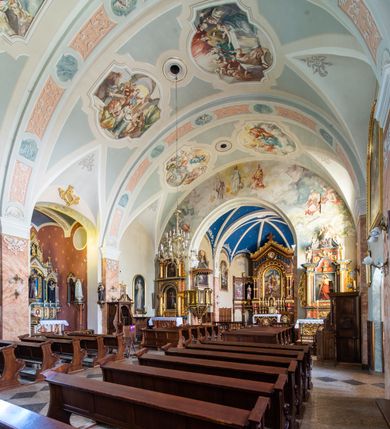 Zdjęcie nr 29: Kościół orientowany, jest budowlą murowaną z cegły i kamienia, na rzucie podłużnym. Korpus nawowy jest jednonawowy i czteroprzęsłowy. Do dwuprzęsłowego, zamkniętego trójbocznie prezbiterium od północy przylega zakrystia. Na osi kościoła, w przedłużeniu północnego przęsła jest czworoboczna, wysunięta przed lico fasady wieża. Od południa do drugiego przęsła korpusu przylega kruchta. Nawa przekryta jest sklepieniem kolebkowym z lunetami wspartymi na pilastrach, w prezbiterium sklepienie krzyżowo-żebrowe z gurtą wspartą na pilastrach. Przestrzeń prezbiterium od korpusu nawowego oddziela półkolista arkada łuku tęczowego i drewniana balustrada. Artykulację ścian na zewnątrz kościoła stanowi zespół dwuuskokowych przypór, w narożach wieży są czterouskokowe, osadzonych na niewysokim cokole. Do wnętrza prowadzą 3 otwory drzwiowe. Dwuskrzydłowe drzwi w fasadzie ujęte są kamiennym obramieniem zamkniętym łukiem koszowym z kluczem pośrodku, wspartym na gzymsie oraz 2 w północnej ścianie kaplicy bocznej. 2 prostokątne prowadzą przez kruchtę i zakrystię. Ściany korpusu nawowego i prezbiterium przeprute są prostokątnymi oknami zamkniętymi łukiem odcinkowym. Okno na zakończeniu prezbiterium jest formie półkoliście zamkniętej niszy z figurą Matki Boskiej. Kształt okien korpusu i prezbiterium został powtórzony w przyległości prezbiterium. Powyżej wejścia na osi wieży małe okienko zamknięte łukiem koszowym, wyżej nisza zamknięta ostrołukowo. W górnej partii wieży znajdują się cztery, duże, zamknięte półkoliście otwory okienne ujęte prostymi obramieniami. Szczyt wierzy obiega gzyms wieńczący z półkolistym łukiem na osi każdej ze ścian. Dach w formie hełmu z latarnią. Dach prezbiterium i korpusu dwuspadowy, kryty blachą, nad pierwszym przęsłem wieżyczka na sygnaturkę. Kruchta z dachem dwuspadowym, przyległość pulpitowym. Tynki w kolorze beżowym i białym. 