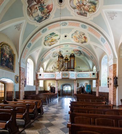 Zdjęcie nr 47: Kościół orientowany, jest budowlą murowaną z cegły i kamienia, na rzucie podłużnym. Korpus nawowy jest jednonawowy i czteroprzęsłowy. Do dwuprzęsłowego, zamkniętego trójbocznie prezbiterium od północy przylega zakrystia. Na osi kościoła, w przedłużeniu północnego przęsła jest czworoboczna, wysunięta przed lico fasady wieża. Od południa do drugiego przęsła korpusu przylega kruchta. Nawa przekryta jest sklepieniem kolebkowym z lunetami wspartymi na pilastrach, w prezbiterium sklepienie krzyżowo-żebrowe z gurtą wspartą na pilastrach. Przestrzeń prezbiterium od korpusu nawowego oddziela półkolista arkada łuku tęczowego i drewniana balustrada. Artykulację ścian na zewnątrz kościoła stanowi zespół dwuuskokowych przypór, w narożach wieży są czterouskokowe, osadzonych na niewysokim cokole. Do wnętrza prowadzą 3 otwory drzwiowe. Dwuskrzydłowe drzwi w fasadzie ujęte są kamiennym obramieniem zamkniętym łukiem koszowym z kluczem pośrodku, wspartym na gzymsie oraz 2 w północnej ścianie kaplicy bocznej. 2 prostokątne prowadzą przez kruchtę i zakrystię. Ściany korpusu nawowego i prezbiterium przeprute są prostokątnymi oknami zamkniętymi łukiem odcinkowym. Okno na zakończeniu prezbiterium jest formie półkoliście zamkniętej niszy z figurą Matki Boskiej. Kształt okien korpusu i prezbiterium został powtórzony w przyległości prezbiterium. Powyżej wejścia na osi wieży małe okienko zamknięte łukiem koszowym, wyżej nisza zamknięta ostrołukowo. W górnej partii wieży znajdują się cztery, duże, zamknięte półkoliście otwory okienne ujęte prostymi obramieniami. Szczyt wierzy obiega gzyms wieńczący z półkolistym łukiem na osi każdej ze ścian. Dach w formie hełmu z latarnią. Dach prezbiterium i korpusu dwuspadowy, kryty blachą, nad pierwszym przęsłem wieżyczka na sygnaturkę. Kruchta z dachem dwuspadowym, przyległość pulpitowym. Tynki w kolorze beżowym i białym. 