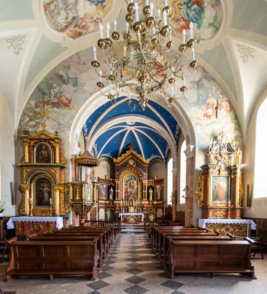 Zdjęcie nr 23: Kościół orientowany, jest budowlą murowaną z cegły i kamienia, na rzucie podłużnym. Korpus nawowy jest jednonawowy i czteroprzęsłowy. Do dwuprzęsłowego, zamkniętego trójbocznie prezbiterium od północy przylega zakrystia. Na osi kościoła, w przedłużeniu północnego przęsła jest czworoboczna, wysunięta przed lico fasady wieża. Od południa do drugiego przęsła korpusu przylega kruchta. Nawa przekryta jest sklepieniem kolebkowym z lunetami wspartymi na pilastrach, w prezbiterium sklepienie krzyżowo-żebrowe z gurtą wspartą na pilastrach. Przestrzeń prezbiterium od korpusu nawowego oddziela półkolista arkada łuku tęczowego i drewniana balustrada. Artykulację ścian na zewnątrz kościoła stanowi zespół dwuuskokowych przypór, w narożach wieży są czterouskokowe, osadzonych na niewysokim cokole. Do wnętrza prowadzą 3 otwory drzwiowe. Dwuskrzydłowe drzwi w fasadzie ujęte są kamiennym obramieniem zamkniętym łukiem koszowym z kluczem pośrodku, wspartym na gzymsie oraz 2 w północnej ścianie kaplicy bocznej. 2 prostokątne prowadzą przez kruchtę i zakrystię. Ściany korpusu nawowego i prezbiterium przeprute są prostokątnymi oknami zamkniętymi łukiem odcinkowym. Okno na zakończeniu prezbiterium jest formie półkoliście zamkniętej niszy z figurą Matki Boskiej. Kształt okien korpusu i prezbiterium został powtórzony w przyległości prezbiterium. Powyżej wejścia na osi wieży małe okienko zamknięte łukiem koszowym, wyżej nisza zamknięta ostrołukowo. W górnej partii wieży znajdują się cztery, duże, zamknięte półkoliście otwory okienne ujęte prostymi obramieniami. Szczyt wierzy obiega gzyms wieńczący z półkolistym łukiem na osi każdej ze ścian. Dach w formie hełmu z latarnią. Dach prezbiterium i korpusu dwuspadowy, kryty blachą, nad pierwszym przęsłem wieżyczka na sygnaturkę. Kruchta z dachem dwuspadowym, przyległość pulpitowym. Tynki w kolorze beżowym i białym. 