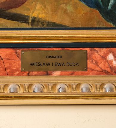 Zdjęcie nr 8: Obraz w kształcie zbliżonym do kwadratu zamkniętego półkolistym łukiem nadwieszonym, ujęty profilowaną, marmoryzowaną, złoconą i srebrzoną ramą z motywem astragalu, przedstawia scenę Zmartwychwstania Jezusa. Pośrodku kompozycji ukazana jest sylwetka unoszącego się Chrystusa zwróconego na wprost, z głową skierowaną w trzech czwartych w prawo. Pociągłą twarz charakteryzują subtelne rysy i krótki zarost. Długie, falowane włosy opadają na plecy i prawe ramię. Nagą, smukłą sylwetkę przesłania w partii bioder czerwony rozwiany płaszcz przewieszony przez prawe ramię. Ręce są rozłożone na boki, lewa uniesiona w geście błogosławieństwa, w prawej Jezus trzyma białą chorągiew z czerwonym krzyżem. Chrystus ukazany jest na tle pokrytego obłokami nieba. Na wysokości jego głowy rozsuwają się, odsłaniając słońce, którego promienie tworzą rodzaj nimbu. Dolną partię kompozycji zajmują sylwetki trzech żołnierzy w zbrojach rzymskich legionistów. Znajdujący się po lewej stronie ukazany jest w pozycji półleżącej. Trzymaną w prawej ręce tarczą osłania się od blasku bijącego od Jezusa. W lewej dłoni ma miecz. W głębi widać fragment kamiennego sarkofagu, którego wieko w postaci dużej, prostopadłościennej płyty zakończonej półkoliście, znajduje się po prawej stronie kompozycji w układzie diagonalnym. Za nim są sylwetki pozostałych dwóch żołnierzy. Pierwszy, skierowany profilem w prawo, przyklękając odwraca się do tyłu. Na głowie ma hełm z pióropuszem, biodra przesłania mu fartuch. W rękach trzyma włócznię. Dalej stoi drugi zwrócony na wprost podnosi do góry zgięte w łokciach ręce, w prawej trzymając miecz. U stóp żołnierzy leżą porzucone płaszcze i elementy uzbrojenia.   
W lewym dolnym rogu obrazu sygnatura „MAL(OWAŁ) ZB(IGNIEW) JUSZCZAK (19)99” .