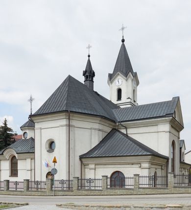 Zdjęcie nr 3: Kościół jest usytuowany pośrodku wsi Waksmund, na północ od głównej drogi z Łopusznej do Nowego Targu. Teren wokół niego jest otoczony żeliwnym płotem na kamiennej podmurówce. Na plac kościelny, od strony północno-wschodniej prowadzi murowana, otynkowana brama, nakryta dwuspadowym daszkiem z rzeźbą św. Michała Archanioła umieszczoną we wnęce nad arkadą od strony zewnętrznej.

Kościół jest orientowany. Bryłę świątyni tworzy trójnawowy korpus (przed rozbudową jednonawowy) z pseudotranseptem, węższe prezbiterium zakończone trójbocznie i wieża od zachodu. Główne wejście do świątyni prowadzi od strony zachodniej poprzez obszerną kruchtę rozbudowaną na szerokość całego kościoła z trójprzęsłową arkadą pośrodku. Osobne wejścia znajdują się od strony południowej poprzez niewielki przedsionek kaplicy oraz od strony północnej poprzez drzwi do zakrystii. Kaplica i zakrystia umieszczone są na zakończeniu naw bocznych od strony wschodniej. Wnętrze świątyni artykułowane jest masywnymi filarami, ustawionymi na styku nawy głównej z nawami bocznymi, które wspierają sklepienia krzyżowo-żebrowe. Nawę główną od prezbiterium, a także od ramion pseudotranseptu oddzielają półkoliście zakończone arkady. Na zakończeniu naw od strony zachodniej, znajdują się chóry muzyczne, głęboko wysunięte ku środkowi kościoła, z wybrzuszoną częścią środkową; w nawie głównej chór wsparty jest na parze kolumn. Nawy są oświetlone umieszczonymi w południowych i północnych ścianach prostokątnymi otworami okiennymi, zamkniętymi półkoliście (większymi na zakończeniu ramion pseudotraseptu i mniejszymi w nawach bocznych oraz w kaplicy i zakrystii). Okna w pseudotransepcie oraz jedno w kaplicy przeszklone są witrażami. Dodatkowe, pojedyncze okrągłe otwory okienne znajdują się w lukarnach oraz na ścianie wschodniej prezbiterium.

W zewnętrznej elewacji kościoła widoczny jest niewysoki, kamienny cokół, wykonany z regularnych ciosów kamienia. Elewacje ścian artykułowane są pionowymi lizenami oraz zakończone są niepełnym belkowaniem z profilowanymi gzymsami, opasującym cały budynek. Wieża jest trójkondygnacyjna, wtopiona w bryłę kościoła, na planie kwadratu. W partii drugiej kondygnacji naroża flankowane są lizenami, znajduje się tam również niewielkie okno od strony zachodniej; trzecia o ściętych narożach, a każda ze ścian przepruta jest otworami oraz dekorowana tarczami zegarowymi. 

Nawa główna z prezbiterium oraz pseduotransept nakryte są dwuspadowymi dachami z ocynkowanej blachy, a nad nawami bocznymi i kruchtą z przodu kościoła położone są dachy wielospadowe z lukarnami. Wieża nakryta jest ośmiobocznym, smukłym dachem wieżowym, zakończonym żeliwnym krzyżem, osadzonym na kuli. Nad kaplicą południową wznosi się niewielka wieżyczka z okrągłymi, małymi okienkami, nakryta ośmiospadowym niewysokim dachem wieżowym z krzyżem w zwieńczeniu, a na skrzyżowaniu nawy głównej z pseudotranseptem umieszczona jest niewielka wieżyczka na sygnaturkę, nakryta dachem wieżowym, zakończonym krzyżem.

