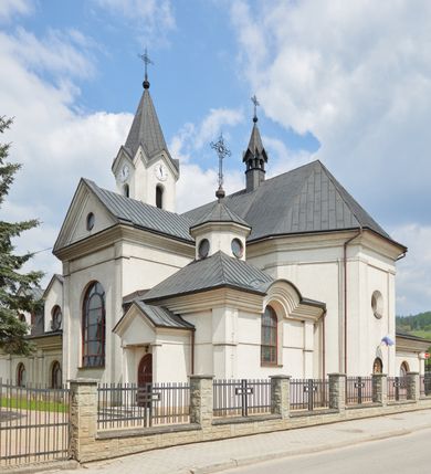 Zdjęcie nr 4: Kościół jest usytuowany pośrodku wsi Waksmund, na północ od głównej drogi z Łopusznej do Nowego Targu. Teren wokół niego jest otoczony żeliwnym płotem na kamiennej podmurówce. Na plac kościelny, od strony północno-wschodniej prowadzi murowana, otynkowana brama, nakryta dwuspadowym daszkiem z rzeźbą św. Michała Archanioła umieszczoną we wnęce nad arkadą od strony zewnętrznej.

Kościół jest orientowany. Bryłę świątyni tworzy trójnawowy korpus (przed rozbudową jednonawowy) z pseudotranseptem, węższe prezbiterium zakończone trójbocznie i wieża od zachodu. Główne wejście do świątyni prowadzi od strony zachodniej poprzez obszerną kruchtę rozbudowaną na szerokość całego kościoła z trójprzęsłową arkadą pośrodku. Osobne wejścia znajdują się od strony południowej poprzez niewielki przedsionek kaplicy oraz od strony północnej poprzez drzwi do zakrystii. Kaplica i zakrystia umieszczone są na zakończeniu naw bocznych od strony wschodniej. Wnętrze świątyni artykułowane jest masywnymi filarami, ustawionymi na styku nawy głównej z nawami bocznymi, które wspierają sklepienia krzyżowo-żebrowe. Nawę główną od prezbiterium, a także od ramion pseudotranseptu oddzielają półkoliście zakończone arkady. Na zakończeniu naw od strony zachodniej, znajdują się chóry muzyczne, głęboko wysunięte ku środkowi kościoła, z wybrzuszoną częścią środkową; w nawie głównej chór wsparty jest na parze kolumn. Nawy są oświetlone umieszczonymi w południowych i północnych ścianach prostokątnymi otworami okiennymi, zamkniętymi półkoliście (większymi na zakończeniu ramion pseudotraseptu i mniejszymi w nawach bocznych oraz w kaplicy i zakrystii). Okna w pseudotransepcie oraz jedno w kaplicy przeszklone są witrażami. Dodatkowe, pojedyncze okrągłe otwory okienne znajdują się w lukarnach oraz na ścianie wschodniej prezbiterium.

W zewnętrznej elewacji kościoła widoczny jest niewysoki, kamienny cokół, wykonany z regularnych ciosów kamienia. Elewacje ścian artykułowane są pionowymi lizenami oraz zakończone są niepełnym belkowaniem z profilowanymi gzymsami, opasującym cały budynek. Wieża jest trójkondygnacyjna, wtopiona w bryłę kościoła, na planie kwadratu. W partii drugiej kondygnacji naroża flankowane są lizenami, znajduje się tam również niewielkie okno od strony zachodniej; trzecia o ściętych narożach, a każda ze ścian przepruta jest otworami oraz dekorowana tarczami zegarowymi. 

Nawa główna z prezbiterium oraz pseduotransept nakryte są dwuspadowymi dachami z ocynkowanej blachy, a nad nawami bocznymi i kruchtą z przodu kościoła położone są dachy wielospadowe z lukarnami. Wieża nakryta jest ośmiobocznym, smukłym dachem wieżowym, zakończonym żeliwnym krzyżem, osadzonym na kuli. Nad kaplicą południową wznosi się niewielka wieżyczka z okrągłymi, małymi okienkami, nakryta ośmiospadowym niewysokim dachem wieżowym z krzyżem w zwieńczeniu, a na skrzyżowaniu nawy głównej z pseudotranseptem umieszczona jest niewielka wieżyczka na sygnaturkę, nakryta dachem wieżowym, zakończonym krzyżem.


