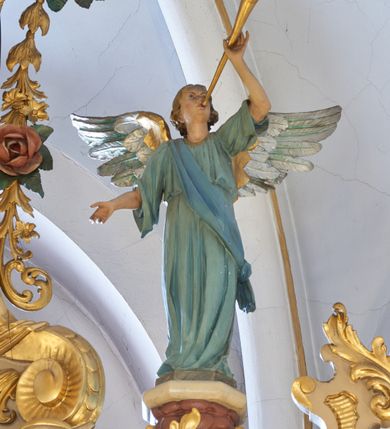 Zdjęcie nr 12: Ołtarz drewniany, zbliżony do prostopadłościanu, zwężający się ku dołowi, zakończony profilowanym gzymsem. Antependium dekorowane płycinami. Mensa drewniana. 

Tabernakulum połączone z tronem wystawienia, trójosiowe, ustawione na wysokim prostopadłościennym cokole, przed który wysunięta jest prostopadłościenna skrzynka tabernakulum. Tabernakulum ustawione na niskim, profilowanym cokole, flankowane pilastrami z płaskorzeźbionym winnym gronem, zamknięte od góry profilowanym gzymsem. Drzwiczki metalowe, groszkowane z aplikowanym kielichem z Hostią w glorii, ujęte esownicami. Tron wystawienia ustawiony nad tabernakulum w formie skrzynki zamkniętej półkoliście dwoma antytetycznymi esownicami, całość zwieńczona figurką baranka leżącego na księdze; nisza obrotowa, z jednej strony wypukła z płaskorzeźbionym przedstawieniem krucyfiksu. Tron flankują dwie ścianki stanowiące tło dla dwóch figur adorujących, czyli klęczących na cokołach aniołów. 

Nastawa ołtarzowa architektoniczna, trójosiowa z bramkami, jednokondygnacyjna ze zwieńczeniem, ustawiona na wysokim, dwustrefowym cokole. Osie wydzielone dwiema parami pilastrów i stojących przed nimi smukłych kolumn o stylizowanych kapitelach kompozytowych i skręconych trzonach na wysokości 2/5. Podpory dźwigają pełne belkowanie wyłamane na ich osi, przyjmujące nad polem środkowym kształt łuku segmentowego; na belkowaniu dwie figury aniołów dmących w trąby na ornamentalnych konsolach. W polu środkowym głęboka nisza ujęta profilowaną ramą w formie stojącego prostokąta, zamkniętego łukiem półkolistym nadwieszonym z figurą Matki Boskiej z Lourdes, na osiach bocznych na ornamentalnych konsolach figury św. Katarzyny po lewej stronie i św. Barbary po prawej stronie. Zwieńczenie w formie stojącego prostokąta zamkniętego półkoliście dwiema antytetycznie ustawionymi wolutami oraz krzyżem na szczycie; boki zwieńczenia ujęte spływami wolutowymi. W polu zwieńczenia obraz z przedstawieniem Trójcy Świętej ujęty profilowaną ramą w formie stojącego prostokąta zamkniętego łukiem półkolistym nadwieszonym oraz stylizowaną archiwoltą. Całość zamknięta dwiema wolutami z liści stylizowanego akantu oraz krzyżykiem. Bramki w formie drzwiczek na wysokości cokołu ołtarza, zamkniętych ukośnie z dekoracją ornamentalną wzdłuż brzegu. Po bokach bramek dwa cokoły wsparte na kolumnach, na których ustawione są rzeźby: św. Piotra po lewej stronie i św. Pawła po drugiej. 

Fryz dekorowany palmetami ujętymi ornamentem roślinnym; nad łukiem niszy środkowej muszla i ornament roślinny; ponad belkowaniem uskrzydlona główka anielska. Na belkowaniu, na osiach skrajnych stylizowane wazony. Zwieńczenie ujęte festonami utworzonymi z róż, kampanuli i wici roślinnej. Struktura polichromowana w kolorze beżowym, jasnoróżowymi i bordowymi akcentami; kolumny, profile i ornamentyka złocone. Po prawej stronie ołtarza sygnatura: "G(RZEGORZ) F(RANCISZEK) BEŁTOWSKI / Nowy Targ / 1909".
