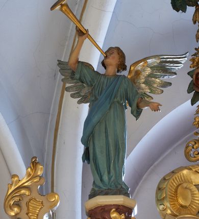 Zdjęcie nr 13: Ołtarz drewniany, zbliżony do prostopadłościanu, zwężający się ku dołowi, zakończony profilowanym gzymsem. Antependium dekorowane płycinami. Mensa drewniana. 

Tabernakulum połączone z tronem wystawienia, trójosiowe, ustawione na wysokim prostopadłościennym cokole, przed który wysunięta jest prostopadłościenna skrzynka tabernakulum. Tabernakulum ustawione na niskim, profilowanym cokole, flankowane pilastrami z płaskorzeźbionym winnym gronem, zamknięte od góry profilowanym gzymsem. Drzwiczki metalowe, groszkowane z aplikowanym kielichem z Hostią w glorii, ujęte esownicami. Tron wystawienia ustawiony nad tabernakulum w formie skrzynki zamkniętej półkoliście dwoma antytetycznymi esownicami, całość zwieńczona figurką baranka leżącego na księdze; nisza obrotowa, z jednej strony wypukła z płaskorzeźbionym przedstawieniem krucyfiksu. Tron flankują dwie ścianki stanowiące tło dla dwóch figur adorujących, czyli klęczących na cokołach aniołów. 

Nastawa ołtarzowa architektoniczna, trójosiowa z bramkami, jednokondygnacyjna ze zwieńczeniem, ustawiona na wysokim, dwustrefowym cokole. Osie wydzielone dwiema parami pilastrów i stojących przed nimi smukłych kolumn o stylizowanych kapitelach kompozytowych i skręconych trzonach na wysokości 2/5. Podpory dźwigają pełne belkowanie wyłamane na ich osi, przyjmujące nad polem środkowym kształt łuku segmentowego; na belkowaniu dwie figury aniołów dmących w trąby na ornamentalnych konsolach. W polu środkowym głęboka nisza ujęta profilowaną ramą w formie stojącego prostokąta, zamkniętego łukiem półkolistym nadwieszonym z figurą Matki Boskiej z Lourdes, na osiach bocznych na ornamentalnych konsolach figury św. Katarzyny po lewej stronie i św. Barbary po prawej stronie. Zwieńczenie w formie stojącego prostokąta zamkniętego półkoliście dwiema antytetycznie ustawionymi wolutami oraz krzyżem na szczycie; boki zwieńczenia ujęte spływami wolutowymi. W polu zwieńczenia obraz z przedstawieniem Trójcy Świętej ujęty profilowaną ramą w formie stojącego prostokąta zamkniętego łukiem półkolistym nadwieszonym oraz stylizowaną archiwoltą. Całość zamknięta dwiema wolutami z liści stylizowanego akantu oraz krzyżykiem. Bramki w formie drzwiczek na wysokości cokołu ołtarza, zamkniętych ukośnie z dekoracją ornamentalną wzdłuż brzegu. Po bokach bramek dwa cokoły wsparte na kolumnach, na których ustawione są rzeźby: św. Piotra po lewej stronie i św. Pawła po drugiej. 

Fryz dekorowany palmetami ujętymi ornamentem roślinnym; nad łukiem niszy środkowej muszla i ornament roślinny; ponad belkowaniem uskrzydlona główka anielska. Na belkowaniu, na osiach skrajnych stylizowane wazony. Zwieńczenie ujęte festonami utworzonymi z róż, kampanuli i wici roślinnej. Struktura polichromowana w kolorze beżowym, jasnoróżowymi i bordowymi akcentami; kolumny, profile i ornamentyka złocone. Po prawej stronie ołtarza sygnatura: "G(RZEGORZ) F(RANCISZEK) BEŁTOWSKI / Nowy Targ / 1909".
