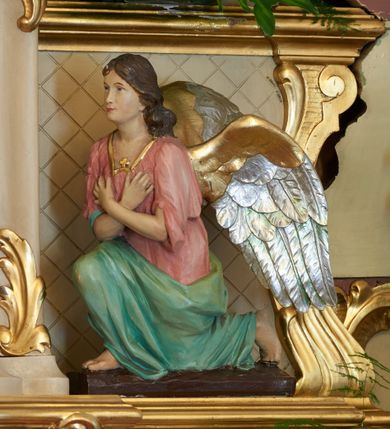 Zdjęcie nr 11: Ołtarz drewniany, zbliżony do prostopadłościanu, zwężający się ku dołowi, zakończony profilowanym gzymsem. Antependium dekorowane płycinami. Mensa drewniana. 

Tabernakulum połączone z tronem wystawienia, trójosiowe, ustawione na wysokim prostopadłościennym cokole, przed który wysunięta jest prostopadłościenna skrzynka tabernakulum. Tabernakulum ustawione na niskim, profilowanym cokole, flankowane pilastrami z płaskorzeźbionym winnym gronem, zamknięte od góry profilowanym gzymsem. Drzwiczki metalowe, groszkowane z aplikowanym kielichem z Hostią w glorii, ujęte esownicami. Tron wystawienia ustawiony nad tabernakulum w formie skrzynki zamkniętej półkoliście dwoma antytetycznymi esownicami, całość zwieńczona figurką baranka leżącego na księdze; nisza obrotowa, z jednej strony wypukła z płaskorzeźbionym przedstawieniem krucyfiksu. Tron flankują dwie ścianki stanowiące tło dla dwóch figur adorujących, czyli klęczących na cokołach aniołów. 

Nastawa ołtarzowa architektoniczna, trójosiowa z bramkami, jednokondygnacyjna ze zwieńczeniem, ustawiona na wysokim, dwustrefowym cokole. Osie wydzielone dwiema parami pilastrów i stojących przed nimi smukłych kolumn o stylizowanych kapitelach kompozytowych i skręconych trzonach na wysokości 2/5. Podpory dźwigają pełne belkowanie wyłamane na ich osi, przyjmujące nad polem środkowym kształt łuku segmentowego; na belkowaniu dwie figury aniołów dmących w trąby na ornamentalnych konsolach. W polu środkowym głęboka nisza ujęta profilowaną ramą w formie stojącego prostokąta, zamkniętego łukiem półkolistym nadwieszonym z figurą Matki Boskiej z Lourdes, na osiach bocznych na ornamentalnych konsolach figury św. Katarzyny po lewej stronie i św. Barbary po prawej stronie. Zwieńczenie w formie stojącego prostokąta zamkniętego półkoliście dwiema antytetycznie ustawionymi wolutami oraz krzyżem na szczycie; boki zwieńczenia ujęte spływami wolutowymi. W polu zwieńczenia obraz z przedstawieniem Trójcy Świętej ujęty profilowaną ramą w formie stojącego prostokąta zamkniętego łukiem półkolistym nadwieszonym oraz stylizowaną archiwoltą. Całość zamknięta dwiema wolutami z liści stylizowanego akantu oraz krzyżykiem. Bramki w formie drzwiczek na wysokości cokołu ołtarza, zamkniętych ukośnie z dekoracją ornamentalną wzdłuż brzegu. Po bokach bramek dwa cokoły wsparte na kolumnach, na których ustawione są rzeźby: św. Piotra po lewej stronie i św. Pawła po drugiej. 

Fryz dekorowany palmetami ujętymi ornamentem roślinnym; nad łukiem niszy środkowej muszla i ornament roślinny; ponad belkowaniem uskrzydlona główka anielska. Na belkowaniu, na osiach skrajnych stylizowane wazony. Zwieńczenie ujęte festonami utworzonymi z róż, kampanuli i wici roślinnej. Struktura polichromowana w kolorze beżowym, jasnoróżowymi i bordowymi akcentami; kolumny, profile i ornamentyka złocone. Po prawej stronie ołtarza sygnatura: "G(RZEGORZ) F(RANCISZEK) BEŁTOWSKI / Nowy Targ / 1909".
