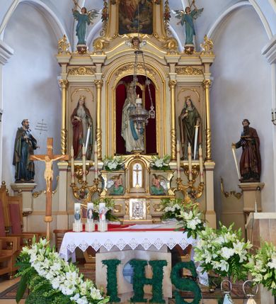 Zdjęcie nr 1: Ołtarz drewniany, zbliżony do prostopadłościanu, zwężający się ku dołowi, zakończony profilowanym gzymsem. Antependium dekorowane płycinami. Mensa drewniana. 

Tabernakulum połączone z tronem wystawienia, trójosiowe, ustawione na wysokim prostopadłościennym cokole, przed który wysunięta jest prostopadłościenna skrzynka tabernakulum. Tabernakulum ustawione na niskim, profilowanym cokole, flankowane pilastrami z płaskorzeźbionym winnym gronem, zamknięte od góry profilowanym gzymsem. Drzwiczki metalowe, groszkowane z aplikowanym kielichem z Hostią w glorii, ujęte esownicami. Tron wystawienia ustawiony nad tabernakulum w formie skrzynki zamkniętej półkoliście dwoma antytetycznymi esownicami, całość zwieńczona figurką baranka leżącego na księdze; nisza obrotowa, z jednej strony wypukła z płaskorzeźbionym przedstawieniem krucyfiksu. Tron flankują dwie ścianki stanowiące tło dla dwóch figur adorujących, czyli klęczących na cokołach aniołów. 

Nastawa ołtarzowa architektoniczna, trójosiowa z bramkami, jednokondygnacyjna ze zwieńczeniem, ustawiona na wysokim, dwustrefowym cokole. Osie wydzielone dwiema parami pilastrów i stojących przed nimi smukłych kolumn o stylizowanych kapitelach kompozytowych i skręconych trzonach na wysokości 2/5. Podpory dźwigają pełne belkowanie wyłamane na ich osi, przyjmujące nad polem środkowym kształt łuku segmentowego; na belkowaniu dwie figury aniołów dmących w trąby na ornamentalnych konsolach. W polu środkowym głęboka nisza ujęta profilowaną ramą w formie stojącego prostokąta, zamkniętego łukiem półkolistym nadwieszonym z figurą Matki Boskiej z Lourdes, na osiach bocznych na ornamentalnych konsolach figury św. Katarzyny po lewej stronie i św. Barbary po prawej stronie. Zwieńczenie w formie stojącego prostokąta zamkniętego półkoliście dwiema antytetycznie ustawionymi wolutami oraz krzyżem na szczycie; boki zwieńczenia ujęte spływami wolutowymi. W polu zwieńczenia obraz z przedstawieniem Trójcy Świętej ujęty profilowaną ramą w formie stojącego prostokąta zamkniętego łukiem półkolistym nadwieszonym oraz stylizowaną archiwoltą. Całość zamknięta dwiema wolutami z liści stylizowanego akantu oraz krzyżykiem. Bramki w formie drzwiczek na wysokości cokołu ołtarza, zamkniętych ukośnie z dekoracją ornamentalną wzdłuż brzegu. Po bokach bramek dwa cokoły wsparte na kolumnach, na których ustawione są rzeźby: św. Piotra po lewej stronie i św. Pawła po drugiej. 

Fryz dekorowany palmetami ujętymi ornamentem roślinnym; nad łukiem niszy środkowej muszla i ornament roślinny; ponad belkowaniem uskrzydlona główka anielska. Na belkowaniu, na osiach skrajnych stylizowane wazony. Zwieńczenie ujęte festonami utworzonymi z róż, kampanuli i wici roślinnej. Struktura polichromowana w kolorze beżowym, jasnoróżowymi i bordowymi akcentami; kolumny, profile i ornamentyka złocone. Po prawej stronie ołtarza sygnatura: "G(RZEGORZ) F(RANCISZEK) BEŁTOWSKI / Nowy Targ / 1909".
