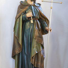 Zdjęcie nr 1: Rzeźba św. Piotra pełnoplastyczna, ustawiona na niskim cokole o ściętych narożach. Święty ukazany jest frontalnie, w pozycji stojącej, w delikatnym kontrapoście z lewą nogą ugiętą w kolanie. W prawej ręce, ugietej w łokciu, trzyma złoty klucz, a w lewej dłoni srebrzony krzyż papieski (ferulę) ze złoconymi gałkami na zakończeniach ramion. Ubrany jest w długą, ciemnozieloną suknię z długimi rękawami, przepasaną w talii paskiem oraz oliwkowozielony płaszcz z kapturem i jasnozieloną podszewką, spięty pod szyją; na stopach ma ciemnobrązowe sandały. Płaszcz zdobiony jest na brzegu szeroką bordiurą w formie stylizowanej wici roślinnej. Twarz podłużna z długim i prostym nosem, wzrokiem skierowanym przed siebie, okolona ciemnobrązową brodą. Na głowie zaznaczona łysina z kępką włosów nad czołem i lokami zawiniętymi po bokach głowy. Polichromia naturalistyczna w odsłoniętych partiach ciała, detale złocone.

