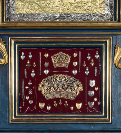 Zdjęcie nr 32: Nastawa architektoniczna, jednoosiowa, jednokondygnacyjna ze zwieńczeniem, ustawiona na wysokim cokole. Ołtarz drewniany, prostopadłościenny, o falistych bokach, mensa drewniana z marmurowym portatylem w drewnianej obudowie. Antepedium ujęte szeroką ramą dekorowaną płaskorzeźbionym motywem wieńca przepasanego wstęgą, w polu medalion z monogramem Marii ujęty wychodzącymi spod jego spodu wiązankami utworzonymi z suchego, wijącego się akantu z karbowaną wstęgą. Nastawa ujęta dwiema parami pilastrów, wewnętrzną z wolutowymi wspornikami w połowie wysokości trzonów oraz zewnętrzną parą o trzonach w formie spływów wolutowych przechodzących w silnie wysunięte do przodu partie cokołu, na których znajdują się postumenty dla figur aniołów. Podpory dźwigają niepełne belkowanie wyłamane na ich osi, nad polem środkowym wyłącznie gzyms przyjmujący kształt łuku półkolistego. Na belkowaniu fragmenty przerwanego, falistego przyczółka oraz para aniołów z kartuszami. W polu środkowym wnęka w formie stojącego prostokąta zamkniętego łukiem segmentowym nadwieszonym z uskokiem, w profilowanej ramie z mniejszym obrazem Matki Boskiej z Dzieciątkiem w kształcie stojącego prostokąta. Poniżej gablota na wota w formie leżącego prostokąta ujęta profilowaną ramą. Kondygnacja flankowana uszami utworzonymi z rocaille&#039;u. Zwieńczenie w formie zbliżonej do kwadratu o wklęsłych bokach przechodzących w woluty, na których siedzą putta, zamknięte fragmentem falistego gzymsu wyłamanego po bokach, na nim rokokowy kartusz z monogramem IHS w polu, flankowany rocaille&#039;em. W polu zwieńczenia rzeźba gołębicy Ducha Świętego w glorii promienistej i otoku z obłoków, w towarzystwie czterech uskrzydlonych główek anielskich. Wszystkie pilastry oraz łuki dekorowane elementami rocaille&#039;u. Struktura w całości polichromowana na sposób imitujący marmoryzację w kolorze niebieskim, ornamentyka i profile złocone, detal srebrzony. 
Wewnątrz skrzyni ołtarzowej napisy „MALOWAŁ LUDWIK WÓJCIK Z KRAKOWA 2 / XI 1914”; „LUDWIK WÓJCIK”; „MALOWALI STOPY”; „23.02.1994 / KONSERWOWALI / KAZIMIERZ PATEJUK / EWA I JERZY SUCHWAŁKO / Z WARSZAWY / PROBOSZCZOWAŁ / KS. BOLESŁAW WAWAK”. 