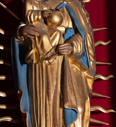 Zdjęcie nr 12: Nastawa ołtarzowa architektoniczna, trójosiowa, jednokondygnacyjna, z predellą. Ołtarz drewniany prostopadłościenny, z drewnianą mensą i portatylem z marmuru dębnickiego. W polu antepedium płycina ujęta blendami i maswerkiem; w centrum monogram Marii w wieńcu róż. Tabernakulum w formie prostopadłościennej skrzynki zamkniętej krenelażem, ujęte dwiema kolumienkami z pinaklami, z prostokątnymi drzwiczkami zamkniętymi łukiem ostrym z płaskorzeźbionym przedstawieniem kielicha, hostią w glorii, winną latoroślą i kłosami zbóż. Osie nastawy wydzielone smukłymi półkolumnami, zakończonymi pinaklami z kwiatonami. Oś środkowa dwukrotnie wyższa i szersza od bocznych. W polu środkowym nisza w formie stojącego prostokąta z figurą Matki Boskiej z Dzieciątkiem. Wnęka ujęta ramą dekorowaną ornamentem roślinnym. Poniżej płycina w kształcie kwadratu zamkniętego łukiem segmentowym, ujęta maswerkową ramą z przedstawieniem Chrystusa z więźniami obozu koncentracyjnego i duchownymi. Oś główna zamknięta baldachimem utworzonym z trzech wimperg oraz szczytem z pinakli i kwiatonów. Osie boczne z wnękami z obrazami bł. Stanisława Pyrtka i bł. Piotra Dańkowskiego, zwieńczonymi baldachimami utworzonymi z trzech wimperg i zakończonymi gotyckimi wieżyczkami. Struktura nastawy politurowana w kolorze jasnobrązowym, ornamentyka i detale architektoniczne złocone. 

