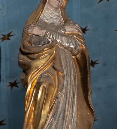 Zdjęcie nr 3: Belka tęczowa o falistym zarysie, zwieńczona profilowanym gzymsem. Z przodu napis „WSZYSCY KTÓRZY PRZYCHO/DZICIE OBACZCIE I UWAŻCIE: / OCZY MOJE BĘDĄ OTWARTE I USZY NACHYLONE NA PROŚBĘ TEGO KTÓRY SIĘ NA TEM MIEJSCU MODLIĆ BĘDZIE.”, na odwrociu napis „TEN KOŚCIÓŁ FUNDOWANY/ PRZEZ BARBARĘ LISICKĄ. / KONSEKROWANY W ROKU 1766. / ODNOMIONY W ROKU 1902. PO RAZ DRUGI W 1980”. Na belce ustawione figury ze sceny Ukrzyżowania. Pośrodku krzyż, do którego przybita jest trzema gwoździami figura umarłego Chrystusa. Ciało w lekkim zwisie o horyzontalnie rozłożonych ramionach, z głową opadającą na prawe ramię, z lekko ugiętymi nogami oraz stopami skrzyżowanymi w układzie prawa na lewą. Twarz ma szczupłą, o zamkniętych oczach, uniesionych brwiach, dużym, wąskim nosie oraz otwartych ustach, okoloną krótką, falowaną brodą i silnie kręconymi włosami opadającymi na ramiona. Na głowie ma koronę cierniową. Ciało jest wychudzone, o silnie zaznaczonych, guzowatych żebrach klatki piersiowej oraz mięśniach i ścięgnach ramion i ud. W partii bioder złocone perizonium zawieszone na sznurze, odsłaniające prawe udo, zawiązane ze zwisem tkaniny na prawym biodrze. 
U dołu krzyża klęczy Maria Magdalena, zwrócona w trzech czwartych w lewo, z uniesioną głową, obiema rękami obejmuje belkę. Twarz ma pociągłą, o małych oczach, krótkim nosie i wąskich ustach, okoloną długimi falowanymi włosami opadającymi na ramiona. Ubrana jest w srebrzoną suknię oraz złocony płaszcz. 
Po prawej stronie krzyża figura Marii, zwrócona w trzech czwartych w lewo, w kontrapoście, z pochyloną głową i rękami skrzyżowanymi na piersi. Twarz ma pociągłą, o wąskich oczach, uniesionych brwiach, małych nosie i ustach. Ubrana jest w srebrzoną suknię oraz złocony płaszcz narzucony na głowę i ramiona, wokół głowy ma białą podwikę. 
Po lewej stronie krzyża św. Jan zwrócony w trzech czwartych w prawo, w kontrapoście, prawą rękę kładzie na piersi, w lewej, opuszczonej trzyma księgę. Twarz ma pociągłą, o wąskich oczach, małych nosie i ustach, okoloną brązowymi, silnie kręconymi włosami, sięgającymi ramion, z czubem nad czołem. Ubrany jest w srebrzoną tunikę z kołnierzykiem, przepasaną w talii oraz złocony płaszcz zarzucony na prawe ramię i podtrzymywany na lewym boku. Polichromia ciał postaci naturalistyczna. 