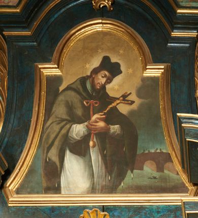 Zdjęcie nr 1: Obraz w formie zbliżonej do trapezu zamkniętego łukiem półkolistym nadwieszonym, o wklęsłych bokach. W centrum św. Jan Nepomucen przedstawiony w półpostaci, zwrócony w trzech czwartych w lewo, z pochyloną głową, z obiema dłońmi złożonymi na piersi, w których trzyma krucyfiks. Twarz ma pociągłą, szczupłą, o dużych, okrągłych oczach skierowanych w dół, wąskim, garbatym nosie i pełnych ustach; okoloną krótką brodą i brązowymi, krótkimi włosami. Na głowie ma czarny biret, a wokół niej nim i wieniec z pięciu gwiazd. Ubrany jest w białą komżę obwiedzioną przy brzegach koronką, almucję zawiązaną pod szyją czerwoną wstążką zakończoną medalionem z wizerunkiem Marii. W tle widoczna scena męczeństwa świętego, gdy zrzucono go z mostu Karola do Wełtawy. Powyżej ukazane nocne, zachmurzone niebo, rozjaśnione na żółto wokół głowy świętego. 
