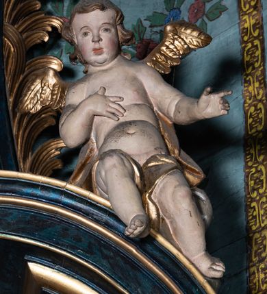 Zdjęcie nr 28: Nastawa architektoniczna, jednoosiowa, jednokondygnacyjna ze zwieńczeniem. Ołtarz prostopadłościenny, murowany, w drewnianej obudowie, z kamienną mensą. 
Antepedium ujęte profilowaną ramą, w polu malowana płycina w formie leżącego prostokąta o wklęsłych narożach, wypełniona wicią roślinną z różami, z kartuszem w centrum. W narożach przedstawienia ptaków na gałęziach. W polu kartusza ukazana półpostać Matki Boskiej Szkaplerznej unoszącej się nad duszami czyśćcowymi, na tle nieba. Retabulum ustawione na wysokim cokole, szerszym od nastawy, z wyłamanymi czterema prostopadłościanami. Nastawa ujęta parą zdwojonych pilastrów i parą stojących przed nimi kolumn o kapitelach kompozytowych, dźwigających pełne belkowanie, wyłamane na ich osi, z architrawem przyjmującym nad polem środkowym formę łuku odcinkowego. Na belkowaniu fragmenty półkolistego, przerwanego przyczółka z siedzącymi puttami. W polu centralnym wnęka w formie stojącego prostokąta zamkniętego łukiem półkolistym nadwieszonym z uskokiem, ujęta profilowaną ramą, z mniejszym obrazem Matki Boskiej z Dzieciątkiem w kształcie stojącego prostokąta. Powyżej, w podłuczu monogram Marii. Nad wnęką, w polu belkowania rocaille'owy kartusz z napisem „SANCTA MARIA / ORA PRO NOBIS”. Na skrajnych partiach cokołu ustawione figury św. Joachima i św. Józefa. Zwieńczenie w formie zbliżonej do trapezu, ujętego spływami wolutowymi, zamkniętego fragmentem gzymsu w formie łuku półkolistego nadwieszonego. Flankowane liśćmi palmowymi, gzyms dekorowany rocaille'm. W polu obraz Matki Boskiej Szkaplerznej ze św. Szymonem Stockiem i św. Teresą z Avili w formie analogicznej do zwieńczenia, w profilowanej ramie. Struktura polichromowana na sposób imitujący marmoryzację w kolorze niebiesko-czarnym, profile i ornamentyka złocone, detal srebrzony. 


