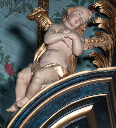 Zdjęcie nr 27: Nastawa architektoniczna, jednoosiowa, jednokondygnacyjna ze zwieńczeniem. Ołtarz prostopadłościenny, murowany, w drewnianej obudowie, z kamienną mensą. 
Antepedium ujęte profilowaną ramą, w polu malowana płycina w formie leżącego prostokąta o wklęsłych narożach, wypełniona wicią roślinną z różami, z kartuszem w centrum. W narożach przedstawienia ptaków na gałęziach. W polu kartusza ukazana półpostać Matki Boskiej Szkaplerznej unoszącej się nad duszami czyśćcowymi, na tle nieba. Retabulum ustawione na wysokim cokole, szerszym od nastawy, z wyłamanymi czterema prostopadłościanami. Nastawa ujęta parą zdwojonych pilastrów i parą stojących przed nimi kolumn o kapitelach kompozytowych, dźwigających pełne belkowanie, wyłamane na ich osi, z architrawem przyjmującym nad polem środkowym formę łuku odcinkowego. Na belkowaniu fragmenty półkolistego, przerwanego przyczółka z siedzącymi puttami. W polu centralnym wnęka w formie stojącego prostokąta zamkniętego łukiem półkolistym nadwieszonym z uskokiem, ujęta profilowaną ramą, z mniejszym obrazem Matki Boskiej z Dzieciątkiem w kształcie stojącego prostokąta. Powyżej, w podłuczu monogram Marii. Nad wnęką, w polu belkowania rocaille&#039;owy kartusz z napisem „SANCTA MARIA / ORA PRO NOBIS”. Na skrajnych partiach cokołu ustawione figury św. Joachima i św. Józefa. Zwieńczenie w formie zbliżonej do trapezu, ujętego spływami wolutowymi, zamkniętego fragmentem gzymsu w formie łuku półkolistego nadwieszonego. Flankowane liśćmi palmowymi, gzyms dekorowany rocaille&#039;m. W polu obraz Matki Boskiej Szkaplerznej ze św. Szymonem Stockiem i św. Teresą z Avili w formie analogicznej do zwieńczenia, w profilowanej ramie. Struktura polichromowana na sposób imitujący marmoryzację w kolorze niebiesko-czarnym, profile i ornamentyka złocone, detal srebrzony. 


