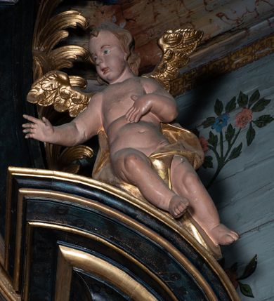 Zdjęcie nr 31: Nastawa architektoniczna, jednoosiowa, jednokondygnacyjna ze zwieńczeniem. Ołtarz prostopadłościenny, murowany, w drewnianej obudowie, z kamienną mensą. 
Antepedium ujęte profilowaną ramą, w polu malowana płycina w formie leżącego prostokąta o wklęsłych narożach, wypełniona wicią roślinną z różami, z kartuszem w centrum. W narożach przedstawienia ptaków na gałęziach. W polu kartusza ukazana półpostać Matki Boskiej Szkaplerznej unoszącej się nad duszami czyśćcowymi, na tle nieba. Retabulum ustawione na wysokim cokole, szerszym od nastawy, z wyłamanymi czterema prostopadłościanami. Nastawa ujęta parą zdwojonych pilastrów i parą stojących przed nimi kolumn o kapitelach kompozytowych, dźwigających pełne belkowanie, wyłamane na ich osi, z architrawem przyjmującym nad polem środkowym formę łuku odcinkowego. Na belkowaniu fragmenty półkolistego, przerwanego przyczółka z siedzącymi puttami. W polu centralnym wnęka w formie stojącego prostokąta zamkniętego łukiem półkolistym nadwieszonym z uskokiem, ujęta profilowaną ramą, z mniejszym obrazem Matki Boskiej z Dzieciątkiem w kształcie stojącego prostokąta. Powyżej, w podłuczu monogram Marii. Nad wnęką, w polu belkowania rocaille'owy kartusz z napisem „SANCTA MARIA / ORA PRO NOBIS”. Na skrajnych partiach cokołu ustawione figury św. Joachima i św. Józefa. Zwieńczenie w formie zbliżonej do trapezu, ujętego spływami wolutowymi, zamkniętego fragmentem gzymsu w formie łuku półkolistego nadwieszonego. Flankowane liśćmi palmowymi, gzyms dekorowany rocaille'm. W polu obraz Matki Boskiej Szkaplerznej ze św. Szymonem Stockiem i św. Teresą z Avili w formie analogicznej do zwieńczenia, w profilowanej ramie. Struktura polichromowana na sposób imitujący marmoryzację w kolorze niebiesko-czarnym, profile i ornamentyka złocone, detal srebrzony. 


