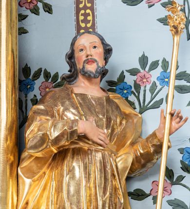 Zdjęcie nr 40: Nastawa architektoniczna, jednoosiowa, jednokondygnacyjna ze zwieńczeniem. Ołtarz prostopadłościenny, murowany, w drewnianej obudowie, z kamienną mensą. 
Antepedium ujęte profilowaną ramą, w polu malowana płycina w formie leżącego prostokąta o wklęsłych narożach, wypełniona wicią roślinną z różami, z kartuszem w centrum. W narożach przedstawienia ptaków na gałęziach. W polu kartusza ukazana półpostać Matki Boskiej Szkaplerznej unoszącej się nad duszami czyśćcowymi, na tle nieba. Retabulum ustawione na wysokim cokole, szerszym od nastawy, z wyłamanymi czterema prostopadłościanami. Nastawa ujęta parą zdwojonych pilastrów i parą stojących przed nimi kolumn o kapitelach kompozytowych, dźwigających pełne belkowanie, wyłamane na ich osi, z architrawem przyjmującym nad polem środkowym formę łuku odcinkowego. Na belkowaniu fragmenty półkolistego, przerwanego przyczółka z siedzącymi puttami. W polu centralnym wnęka w formie stojącego prostokąta zamkniętego łukiem półkolistym nadwieszonym z uskokiem, ujęta profilowaną ramą, z mniejszym obrazem Matki Boskiej z Dzieciątkiem w kształcie stojącego prostokąta. Powyżej, w podłuczu monogram Marii. Nad wnęką, w polu belkowania rocaille'owy kartusz z napisem „SANCTA MARIA / ORA PRO NOBIS”. Na skrajnych partiach cokołu ustawione figury św. Joachima i św. Józefa. Zwieńczenie w formie zbliżonej do trapezu, ujętego spływami wolutowymi, zamkniętego fragmentem gzymsu w formie łuku półkolistego nadwieszonego. Flankowane liśćmi palmowymi, gzyms dekorowany rocaille'm. W polu obraz Matki Boskiej Szkaplerznej ze św. Szymonem Stockiem i św. Teresą z Avili w formie analogicznej do zwieńczenia, w profilowanej ramie. Struktura polichromowana na sposób imitujący marmoryzację w kolorze niebiesko-czarnym, profile i ornamentyka złocone, detal srebrzony. 


