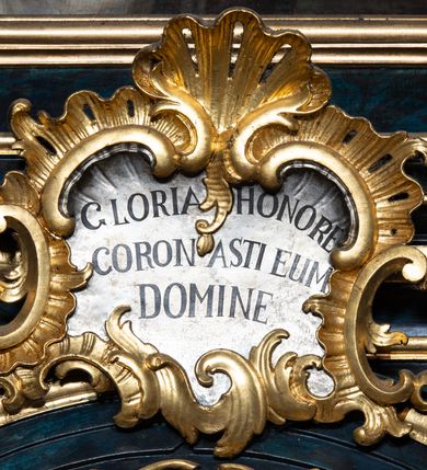 Zdjęcie nr 14: Nastawa architektoniczna, jednoosiowa, jednokondygnacyjna ze zwieńczeniem. Ołtarz prostopadłościenny, murowany, w drewnianej obudowie, z kamienną mensą. 
Antepedium ujęte profilowaną ramą, w polu malowana płycina w formie leżącego prostokąta o wklęsłych narożach, wypełniona wicią roślinną z różami, z kartuszem w centrum. W narożach przedstawienia ptaków na gałęziach. W polu kartusza scena męczeństwa św. Walentego, na tle pejzażu. Retabulum ustawione na wysokim cokole, szerszym od nastawy, z wyłamanymi czterema prostopadłościanami. Nastawa ujęta parą zdwojonych pilastrów i parą stojących przed nimi kolumn o kapitelach kompozytowych, dźwigających pełne belkowanie, wyłamane na ich osi, z architrawem przyjmującym nad polem środkowym formę łuku odcinkowego. Na belkowaniu fragmenty półkolistego, przerwanego przyczółka z siedzącymi puttami. W polu centralnym wnęka w formie stojącego prostokąta zamkniętego łukiem półkolistym nadwieszonym z uskokiem, ujęta profilowaną ramą, z obrazem św. Walentego. Nad nią, w polu belkowania rocaille&#039;owy kartusz z napisem „GLORIA HONORE / CORONASTI EUM / DOMINE”. Na skrajnych partiach cokołu ustawione figury św. Jana od Krzyża i św. Jana Kapistrana (?). Zwieńczenie w formie zbliżonej do trapezu, ujętego spływami wolutowymi, zamkniętego fragmentem gzymsu w formie łuku półkolistego nadwieszonego. Zwieńczenie flankowane liśćmi palmowymi, gzyms dekorowany rocaille&#039;m. W polu obraz św. Jana Nepomucena w kształcie analogicznym do zwieńczenia, w profilowanej ramie. Struktura polichromowana na sposób imitujący marmoryzację w kolorze niebieskim, profile i ornamentyka złocone, detal srebrzony. 

