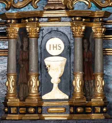 Zdjęcie nr 17: Nastawa architektoniczna, jednoosiowa, jednokondygnacyjna ze zwieńczeniem. Ołtarz prostopadłościenny, murowany, w drewnianej obudowie, z kamienną mensą. 
Antepedium ujęte profilowaną ramą, w polu malowana płycina w formie leżącego prostokąta o wklęsłych narożach, wypełniona wicią roślinną z różami, z kartuszem w centrum. W narożach przedstawienia ptaków na gałęziach. W polu kartusza scena męczeństwa św. Walentego, na tle pejzażu. Retabulum ustawione na wysokim cokole, szerszym od nastawy, z wyłamanymi czterema prostopadłościanami. Nastawa ujęta parą zdwojonych pilastrów i parą stojących przed nimi kolumn o kapitelach kompozytowych, dźwigających pełne belkowanie, wyłamane na ich osi, z architrawem przyjmującym nad polem środkowym formę łuku odcinkowego. Na belkowaniu fragmenty półkolistego, przerwanego przyczółka z siedzącymi puttami. W polu centralnym wnęka w formie stojącego prostokąta zamkniętego łukiem półkolistym nadwieszonym z uskokiem, ujęta profilowaną ramą, z obrazem św. Walentego. Nad nią, w polu belkowania rocaille&#039;owy kartusz z napisem „GLORIA HONORE / CORONASTI EUM / DOMINE”. Na skrajnych partiach cokołu ustawione figury św. Jana od Krzyża i św. Jana Kapistrana (?). Zwieńczenie w formie zbliżonej do trapezu, ujętego spływami wolutowymi, zamkniętego fragmentem gzymsu w formie łuku półkolistego nadwieszonego. Zwieńczenie flankowane liśćmi palmowymi, gzyms dekorowany rocaille&#039;m. W polu obraz św. Jana Nepomucena w kształcie analogicznym do zwieńczenia, w profilowanej ramie. Struktura polichromowana na sposób imitujący marmoryzację w kolorze niebieskim, profile i ornamentyka złocone, detal srebrzony. 

