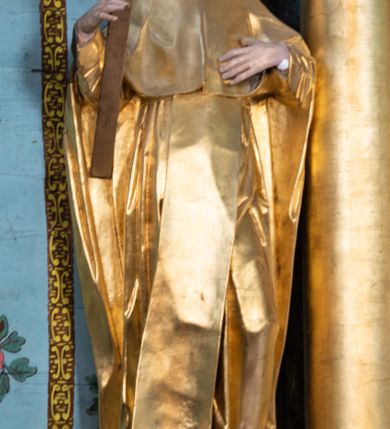 Zdjęcie nr 24: Nastawa architektoniczna, jednoosiowa, jednokondygnacyjna ze zwieńczeniem. Ołtarz prostopadłościenny, murowany, w drewnianej obudowie, z kamienną mensą. 
Antepedium ujęte profilowaną ramą, w polu malowana płycina w formie leżącego prostokąta o wklęsłych narożach, wypełniona wicią roślinną z różami, z kartuszem w centrum. W narożach przedstawienia ptaków na gałęziach. W polu kartusza scena męczeństwa św. Walentego, na tle pejzażu. Retabulum ustawione na wysokim cokole, szerszym od nastawy, z wyłamanymi czterema prostopadłościanami. Nastawa ujęta parą zdwojonych pilastrów i parą stojących przed nimi kolumn o kapitelach kompozytowych, dźwigających pełne belkowanie, wyłamane na ich osi, z architrawem przyjmującym nad polem środkowym formę łuku odcinkowego. Na belkowaniu fragmenty półkolistego, przerwanego przyczółka z siedzącymi puttami. W polu centralnym wnęka w formie stojącego prostokąta zamkniętego łukiem półkolistym nadwieszonym z uskokiem, ujęta profilowaną ramą, z obrazem św. Walentego. Nad nią, w polu belkowania rocaille&#039;owy kartusz z napisem „GLORIA HONORE / CORONASTI EUM / DOMINE”. Na skrajnych partiach cokołu ustawione figury św. Jana od Krzyża i św. Jana Kapistrana (?). Zwieńczenie w formie zbliżonej do trapezu, ujętego spływami wolutowymi, zamkniętego fragmentem gzymsu w formie łuku półkolistego nadwieszonego. Zwieńczenie flankowane liśćmi palmowymi, gzyms dekorowany rocaille&#039;m. W polu obraz św. Jana Nepomucena w kształcie analogicznym do zwieńczenia, w profilowanej ramie. Struktura polichromowana na sposób imitujący marmoryzację w kolorze niebieskim, profile i ornamentyka złocone, detal srebrzony. 

