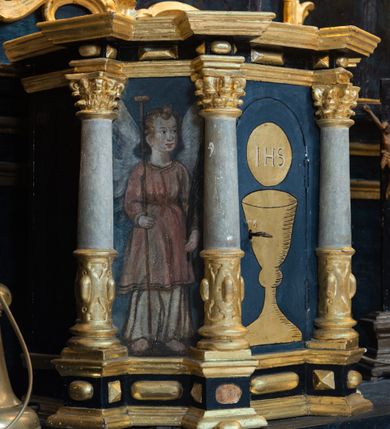 Zdjęcie nr 20: Nastawa architektoniczna, jednoosiowa, jednokondygnacyjna ze zwieńczeniem. Ołtarz prostopadłościenny, murowany, w drewnianej obudowie, z kamienną mensą. 
Antepedium ujęte profilowaną ramą, w polu malowana płycina w formie leżącego prostokąta o wklęsłych narożach, wypełniona wicią roślinną z różami, z kartuszem w centrum. W narożach przedstawienia ptaków na gałęziach. W polu kartusza scena męczeństwa św. Walentego, na tle pejzażu. Retabulum ustawione na wysokim cokole, szerszym od nastawy, z wyłamanymi czterema prostopadłościanami. Nastawa ujęta parą zdwojonych pilastrów i parą stojących przed nimi kolumn o kapitelach kompozytowych, dźwigających pełne belkowanie, wyłamane na ich osi, z architrawem przyjmującym nad polem środkowym formę łuku odcinkowego. Na belkowaniu fragmenty półkolistego, przerwanego przyczółka z siedzącymi puttami. W polu centralnym wnęka w formie stojącego prostokąta zamkniętego łukiem półkolistym nadwieszonym z uskokiem, ujęta profilowaną ramą, z obrazem św. Walentego. Nad nią, w polu belkowania rocaille&#039;owy kartusz z napisem „GLORIA HONORE / CORONASTI EUM / DOMINE”. Na skrajnych partiach cokołu ustawione figury św. Jana od Krzyża i św. Jana Kapistrana (?). Zwieńczenie w formie zbliżonej do trapezu, ujętego spływami wolutowymi, zamkniętego fragmentem gzymsu w formie łuku półkolistego nadwieszonego. Zwieńczenie flankowane liśćmi palmowymi, gzyms dekorowany rocaille&#039;m. W polu obraz św. Jana Nepomucena w kształcie analogicznym do zwieńczenia, w profilowanej ramie. Struktura polichromowana na sposób imitujący marmoryzację w kolorze niebieskim, profile i ornamentyka złocone, detal srebrzony. 

