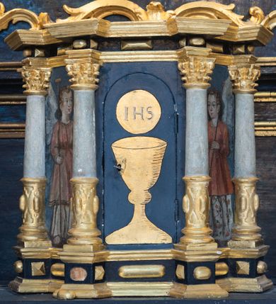 Zdjęcie nr 18: Nastawa architektoniczna, jednoosiowa, jednokondygnacyjna ze zwieńczeniem. Ołtarz prostopadłościenny, murowany, w drewnianej obudowie, z kamienną mensą. 
Antepedium ujęte profilowaną ramą, w polu malowana płycina w formie leżącego prostokąta o wklęsłych narożach, wypełniona wicią roślinną z różami, z kartuszem w centrum. W narożach przedstawienia ptaków na gałęziach. W polu kartusza scena męczeństwa św. Walentego, na tle pejzażu. Retabulum ustawione na wysokim cokole, szerszym od nastawy, z wyłamanymi czterema prostopadłościanami. Nastawa ujęta parą zdwojonych pilastrów i parą stojących przed nimi kolumn o kapitelach kompozytowych, dźwigających pełne belkowanie, wyłamane na ich osi, z architrawem przyjmującym nad polem środkowym formę łuku odcinkowego. Na belkowaniu fragmenty półkolistego, przerwanego przyczółka z siedzącymi puttami. W polu centralnym wnęka w formie stojącego prostokąta zamkniętego łukiem półkolistym nadwieszonym z uskokiem, ujęta profilowaną ramą, z obrazem św. Walentego. Nad nią, w polu belkowania rocaille&#039;owy kartusz z napisem „GLORIA HONORE / CORONASTI EUM / DOMINE”. Na skrajnych partiach cokołu ustawione figury św. Jana od Krzyża i św. Jana Kapistrana (?). Zwieńczenie w formie zbliżonej do trapezu, ujętego spływami wolutowymi, zamkniętego fragmentem gzymsu w formie łuku półkolistego nadwieszonego. Zwieńczenie flankowane liśćmi palmowymi, gzyms dekorowany rocaille&#039;m. W polu obraz św. Jana Nepomucena w kształcie analogicznym do zwieńczenia, w profilowanej ramie. Struktura polichromowana na sposób imitujący marmoryzację w kolorze niebieskim, profile i ornamentyka złocone, detal srebrzony. 

