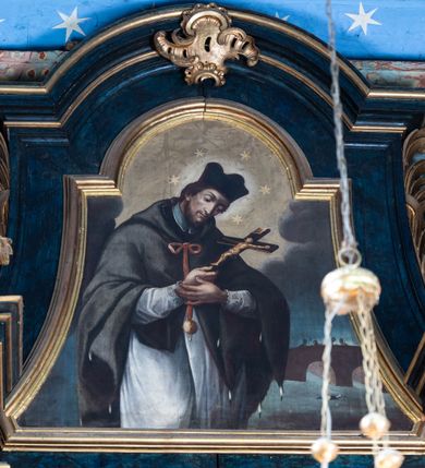 Zdjęcie nr 13: Nastawa architektoniczna, jednoosiowa, jednokondygnacyjna ze zwieńczeniem. Ołtarz prostopadłościenny, murowany, w drewnianej obudowie, z kamienną mensą. 
Antepedium ujęte profilowaną ramą, w polu malowana płycina w formie leżącego prostokąta o wklęsłych narożach, wypełniona wicią roślinną z różami, z kartuszem w centrum. W narożach przedstawienia ptaków na gałęziach. W polu kartusza scena męczeństwa św. Walentego, na tle pejzażu. Retabulum ustawione na wysokim cokole, szerszym od nastawy, z wyłamanymi czterema prostopadłościanami. Nastawa ujęta parą zdwojonych pilastrów i parą stojących przed nimi kolumn o kapitelach kompozytowych, dźwigających pełne belkowanie, wyłamane na ich osi, z architrawem przyjmującym nad polem środkowym formę łuku odcinkowego. Na belkowaniu fragmenty półkolistego, przerwanego przyczółka z siedzącymi puttami. W polu centralnym wnęka w formie stojącego prostokąta zamkniętego łukiem półkolistym nadwieszonym z uskokiem, ujęta profilowaną ramą, z obrazem św. Walentego. Nad nią, w polu belkowania rocaille'owy kartusz z napisem „GLORIA HONORE / CORONASTI EUM / DOMINE”. Na skrajnych partiach cokołu ustawione figury św. Jana od Krzyża i św. Jana Kapistrana (?). Zwieńczenie w formie zbliżonej do trapezu, ujętego spływami wolutowymi, zamkniętego fragmentem gzymsu w formie łuku półkolistego nadwieszonego. Zwieńczenie flankowane liśćmi palmowymi, gzyms dekorowany rocaille'm. W polu obraz św. Jana Nepomucena w kształcie analogicznym do zwieńczenia, w profilowanej ramie. Struktura polichromowana na sposób imitujący marmoryzację w kolorze niebieskim, profile i ornamentyka złocone, detal srebrzony. 

