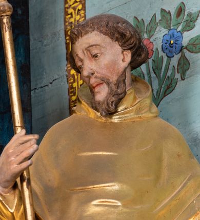 Zdjęcie nr 34: Nastawa architektoniczna, jednoosiowa, jednokondygnacyjna ze zwieńczeniem. Ołtarz prostopadłościenny, murowany, w drewnianej obudowie, z kamienną mensą. 
Antepedium ujęte profilowaną ramą, w polu malowana płycina w formie leżącego prostokąta o wklęsłych narożach, wypełniona wicią roślinną z różami, z kartuszem w centrum. W narożach przedstawienia ptaków na gałęziach. W polu kartusza scena męczeństwa św. Walentego, na tle pejzażu. Retabulum ustawione na wysokim cokole, szerszym od nastawy, z wyłamanymi czterema prostopadłościanami. Nastawa ujęta parą zdwojonych pilastrów i parą stojących przed nimi kolumn o kapitelach kompozytowych, dźwigających pełne belkowanie, wyłamane na ich osi, z architrawem przyjmującym nad polem środkowym formę łuku odcinkowego. Na belkowaniu fragmenty półkolistego, przerwanego przyczółka z siedzącymi puttami. W polu centralnym wnęka w formie stojącego prostokąta zamkniętego łukiem półkolistym nadwieszonym z uskokiem, ujęta profilowaną ramą, z obrazem św. Walentego. Nad nią, w polu belkowania rocaille'owy kartusz z napisem „GLORIA HONORE / CORONASTI EUM / DOMINE”. Na skrajnych partiach cokołu ustawione figury św. Jana od Krzyża i św. Jana Kapistrana (?). Zwieńczenie w formie zbliżonej do trapezu, ujętego spływami wolutowymi, zamkniętego fragmentem gzymsu w formie łuku półkolistego nadwieszonego. Zwieńczenie flankowane liśćmi palmowymi, gzyms dekorowany rocaille'm. W polu obraz św. Jana Nepomucena w kształcie analogicznym do zwieńczenia, w profilowanej ramie. Struktura polichromowana na sposób imitujący marmoryzację w kolorze niebieskim, profile i ornamentyka złocone, detal srebrzony. 

