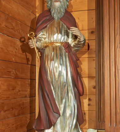 Zdjęcie nr 1: Rzeźba drążona, ustawiona na podstawie na plenie kwadratu. Święty ukazany frontalnie, z obiema ugiętymi rękami, przyciśniętymi do ciała, w prawej dłoni ma klucz. Twarz ma pociągłą, o starczych rysach, z wysokim czołem, o migdałowatych, opadających oczach, dużym, prostym nosie i wąskich, długich ustach; okoloną siwą, długą i falistą brodą oraz kręconymi włosami sięgającymi ramion, na głowie ma łysinę. Ubrany jest w srebrzoną tunikę, o regularnych fałdach, przepasaną w talii złoconą szarfą. Na ramiona ma narzucony ciemnoczerwony płaszcz, ściśle przylegający do ciała, związany u pasa na lewym biodrze, na stopach ma buty. Polichromia ciała naturalistyczna.