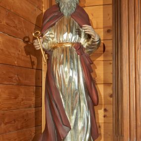 Zdjęcie nr 1: Rzeźba drążona, ustawiona na podstawie na plenie kwadratu. Święty ukazany frontalnie, z obiema ugiętymi rękami, przyciśniętymi do ciała, w prawej dłoni ma klucz. Twarz ma pociągłą, o starczych rysach, z wysokim czołem, o migdałowatych, opadających oczach, dużym, prostym nosie i wąskich, długich ustach; okoloną siwą, długą i falistą brodą oraz kręconymi włosami sięgającymi ramion, na głowie ma łysinę. Ubrany jest w srebrzoną tunikę, o regularnych fałdach, przepasaną w talii złoconą szarfą. Na ramiona ma narzucony ciemnoczerwony płaszcz, ściśle przylegający do ciała, związany u pasa na lewym biodrze, na stopach ma buty. Polichromia ciała naturalistyczna.