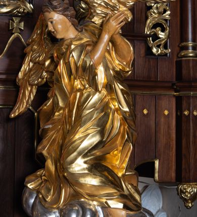 Zdjęcie nr 4: Nastawa architektoniczna, trójosiowa, jednokondygnacyjna ze zwieńczeniem, z predellą. Ołtarz prostopadłościenny, z drewnianą mensą i kamiennym portatylem. Antepedium ujęte grubą opaską, w polu płaskorzeźbiona otwarta księga z napisem „UBODZY / SKARBEM / KOŚCIOŁA” z liściem palmy i kratą. Na mensie tabernakulum w formie drewnianej skrzynki flankowanej pinaklami z kwiatonami. Drzwiczki w kształcie prostokąta zamkniętego łukiem ostrym, w ramie, z przedstawieniem baranka apokaliptycznego. Tabernakulum flankowane dwiema figurami klęczących na obłokach aniołów.  Osie nastawy wydzielone wąskimi kolumnami dźwigającymi stylizowane pinakle. W polu środkowym wnęka w formie stojącego prostokąta zamkniętego łukiem odcinkowym nadwieszonym, z obrazem św. Wawrzyńca, ujętym ramą zdobioną ornamentem roślinnym. W polach osi bocznych po dwie ażurowe stylizowane blendy wypełnione ornamentem roślinnym, pomiędzy nimi, w górnej partii, ośmioboczne wsporniki, na których stoją figury św. Izydora i św. Kryspina. Zwieńczenie w formie ośmiobocznego cokołu z figurą św. Józefa, flankowanego dwiema parami pinakli i blendami z dekoracja roślinną. Struktura pokryta politurą w kolorze ciemnobrązowym, ornamentyka i detale architektoniczne złocone. 
