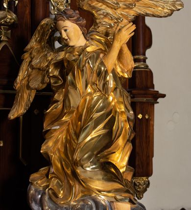 Zdjęcie nr 3: Nastawa architektoniczna, trójosiowa, jednokondygnacyjna ze zwieńczeniem, z predellą. Ołtarz prostopadłościenny, z drewnianą mensą i kamiennym portatylem. Antepedium ujęte grubą opaską, w polu płaskorzeźbiona otwarta księga z napisem „UBODZY / SKARBEM / KOŚCIOŁA” z liściem palmy i kratą. Na mensie tabernakulum w formie drewnianej skrzynki flankowanej pinaklami z kwiatonami. Drzwiczki w kształcie prostokąta zamkniętego łukiem ostrym, w ramie, z przedstawieniem baranka apokaliptycznego. Tabernakulum flankowane dwiema figurami klęczących na obłokach aniołów.  Osie nastawy wydzielone wąskimi kolumnami dźwigającymi stylizowane pinakle. W polu środkowym wnęka w formie stojącego prostokąta zamkniętego łukiem odcinkowym nadwieszonym, z obrazem św. Wawrzyńca, ujętym ramą zdobioną ornamentem roślinnym. W polach osi bocznych po dwie ażurowe stylizowane blendy wypełnione ornamentem roślinnym, pomiędzy nimi, w górnej partii, ośmioboczne wsporniki, na których stoją figury św. Izydora i św. Kryspina. Zwieńczenie w formie ośmiobocznego cokołu z figurą św. Józefa, flankowanego dwiema parami pinakli i blendami z dekoracja roślinną. Struktura pokryta politurą w kolorze ciemnobrązowym, ornamentyka i detale architektoniczne złocone. 
