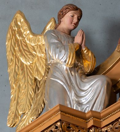 Zdjęcie nr 11: Nastawa ołtarzowa architektoniczna, jednoosiowa, jednokondygnacyjna z bramkami i zwieńczeniem, ustawiona na wysokim, dwustrefowym cokole. Ołtarz prostopadłościenny, murowany, umieszczony w drewnianej obudowie. Antependium ujęte ramą dekorowaną plecionką, podzielone na trzy pola: w środkowym płaskorzeźbione przedstawienie Ostatniej Wieczerzy według Leonarda da Vinci, a po bokach ornament roślinny o wertykalnym układzie.

Tabernakulum architektoniczne, jednokondygnacyjne, trójosiowe, ustawione na zdwojonym na cokole z dwoma zwieńczeniami na osiach skrajnych. Osie wydzielone są parami kolumn o kapitelach kompozytowych, oś środkowa wysunięta do przodu. Podpory dźwigają pełne belkowanie wyłamane na ich linii, przerwane nad polem środkowym, gdzie kolumny dźwigają przerwany półkolisty przyczółek połączony z łukiem gzymsu, nad nim ustawiona jest rzeźba Baranka leżącego na księdze z siedmioma pieczęciami. W polu środkowym dwuskrzydłowe drzwiczki do metalowego tabernakulum ujęte ramą w formie stojącego prostokąta, zamkniętego łukiem nadwieszonym z długim uskokiem. Na drzwiczkach znajdują się dwa aplikowane klęczące anioły, powyżej Chrismo w medalionie, otoczonym glorią. W osiach bocznych są nisze zamknięte konchami z figurkami aniołów, zamknięte zwieńczeniami w formie stojących prostokątów z falistym gzymsem i gałązkami lilii na szczycie; w polu srebrzone, owalne medaliony. Po bokach kondygnacji na wolutowych uszach oraz po bokach zwieńczeń znajdują się wazony ze słonecznikami. Cokół zdobiony jest ornamentem akantowym.

Kondygnacja ujęta jest dwiema parami kolumn o kapitelach kompozytowych oraz stojącą między nimi parą filarów. Podpory dźwigają pełne belkowanie o silnie wysuniętym gzymsie, wyłamane na osiach bocznych, z podwieszonymi szyszkami na tle filarów; przerwane nad polem środkowym. W centrum pole w formie stojącego prostokąta ujęte ramą dekorowaną ornamentem roślinnym z płaskorzeźbionym przedstawieniem Matki Boskiej z Dzieciątkiem. Na zasuwie obrazy: „Najświętsze Serce Pana Jezusa”, „Zwiastowanie” oraz „Św. Mikołaj”. Nad bramkami oraz pomiędzy kolumnami ustawione są rzeźby. Od lewej kolejno: św. Andrzej, św. Wojciech, św. Stanisław i na końcu po prawej św. Tomasz. Nad polem głównym znajduje się przeszklony prześwit w formie półkola z rzeźbioną gołębicą Ducha Świętego na tle glorii. Powyżej pole zamknięte półkoliście fragmentem gzymsu z rzeźbionym popiersiem błogosławiącego Boga Ojca pośród obłoków. Zwieńczenie w formie zbliżonej do stojącego prostokąta o wklęsłych bokach z gzymsem i z podwieszonym lambrekinem oraz kotarami spływającymi na boki. W polu przeszklony prześwit w formie kwadratu zamkniętego łukiem nadwieszonym z rzeźbionym monogramem Marii na tle glorii. Po bokach zwieńczenia ustawione są dwie duże figury klęczących aniołów.

Bramki po bokach ołtarza ustawione są na wysokości cokołu nastawy; przejścia ujęte są parą kanelowanych pilastrów, zamknięte łukiem utworzonym z dwóch przeciwstawnych wolut wspierających wieńczące cokoły. Przejścia w formie wydłużonego stojącego prostokąta zamkniętego łukiem półkolistym nadwieszonym.

Całość ołtarza oprócz tabernakulum dekorowana jest ornamentem małżowinowo-chrząstkowym. Uszy flankujące kondygnację utworzone są również z ornamentu małżowinowo-chrząstkowego. Na zamknięciu zwieńczenia znajdują się dwie uskrzydlone główki anielskie skierowane na wprost z podwieszonymi u szyi chustami. Struktura ołtarza polichromowana jest w kolorze brązowym ze złoconymi kolumnami, ornamentyką i profilami, detale srebrzone.