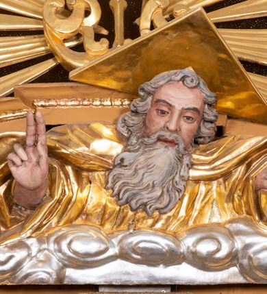 Zdjęcie nr 7: Nastawa ołtarzowa architektoniczna, jednoosiowa, jednokondygnacyjna z bramkami i zwieńczeniem, ustawiona na wysokim, dwustrefowym cokole. Ołtarz prostopadłościenny, murowany, umieszczony w drewnianej obudowie. Antependium ujęte ramą dekorowaną plecionką, podzielone na trzy pola: w środkowym płaskorzeźbione przedstawienie Ostatniej Wieczerzy według Leonarda da Vinci, a po bokach ornament roślinny o wertykalnym układzie.

Tabernakulum architektoniczne, jednokondygnacyjne, trójosiowe, ustawione na zdwojonym na cokole z dwoma zwieńczeniami na osiach skrajnych. Osie wydzielone są parami kolumn o kapitelach kompozytowych, oś środkowa wysunięta do przodu. Podpory dźwigają pełne belkowanie wyłamane na ich linii, przerwane nad polem środkowym, gdzie kolumny dźwigają przerwany półkolisty przyczółek połączony z łukiem gzymsu, nad nim ustawiona jest rzeźba Baranka leżącego na księdze z siedmioma pieczęciami. W polu środkowym dwuskrzydłowe drzwiczki do metalowego tabernakulum ujęte ramą w formie stojącego prostokąta, zamkniętego łukiem nadwieszonym z długim uskokiem. Na drzwiczkach znajdują się dwa aplikowane klęczące anioły, powyżej Chrismo w medalionie, otoczonym glorią. W osiach bocznych są nisze zamknięte konchami z figurkami aniołów, zamknięte zwieńczeniami w formie stojących prostokątów z falistym gzymsem i gałązkami lilii na szczycie; w polu srebrzone, owalne medaliony. Po bokach kondygnacji na wolutowych uszach oraz po bokach zwieńczeń znajdują się wazony ze słonecznikami. Cokół zdobiony jest ornamentem akantowym.

Kondygnacja ujęta jest dwiema parami kolumn o kapitelach kompozytowych oraz stojącą między nimi parą filarów. Podpory dźwigają pełne belkowanie o silnie wysuniętym gzymsie, wyłamane na osiach bocznych, z podwieszonymi szyszkami na tle filarów; przerwane nad polem środkowym. W centrum pole w formie stojącego prostokąta ujęte ramą dekorowaną ornamentem roślinnym z płaskorzeźbionym przedstawieniem Matki Boskiej z Dzieciątkiem. Na zasuwie obrazy: „Najświętsze Serce Pana Jezusa”, „Zwiastowanie” oraz „Św. Mikołaj”. Nad bramkami oraz pomiędzy kolumnami ustawione są rzeźby. Od lewej kolejno: św. Andrzej, św. Wojciech, św. Stanisław i na końcu po prawej św. Tomasz. Nad polem głównym znajduje się przeszklony prześwit w formie półkola z rzeźbioną gołębicą Ducha Świętego na tle glorii. Powyżej pole zamknięte półkoliście fragmentem gzymsu z rzeźbionym popiersiem błogosławiącego Boga Ojca pośród obłoków. Zwieńczenie w formie zbliżonej do stojącego prostokąta o wklęsłych bokach z gzymsem i z podwieszonym lambrekinem oraz kotarami spływającymi na boki. W polu przeszklony prześwit w formie kwadratu zamkniętego łukiem nadwieszonym z rzeźbionym monogramem Marii na tle glorii. Po bokach zwieńczenia ustawione są dwie duże figury klęczących aniołów.

Bramki po bokach ołtarza ustawione są na wysokości cokołu nastawy; przejścia ujęte są parą kanelowanych pilastrów, zamknięte łukiem utworzonym z dwóch przeciwstawnych wolut wspierających wieńczące cokoły. Przejścia w formie wydłużonego stojącego prostokąta zamkniętego łukiem półkolistym nadwieszonym.

Całość ołtarza oprócz tabernakulum dekorowana jest ornamentem małżowinowo-chrząstkowym. Uszy flankujące kondygnację utworzone są również z ornamentu małżowinowo-chrząstkowego. Na zamknięciu zwieńczenia znajdują się dwie uskrzydlone główki anielskie skierowane na wprost z podwieszonymi u szyi chustami. Struktura ołtarza polichromowana jest w kolorze brązowym ze złoconymi kolumnami, ornamentyką i profilami, detale srebrzone.