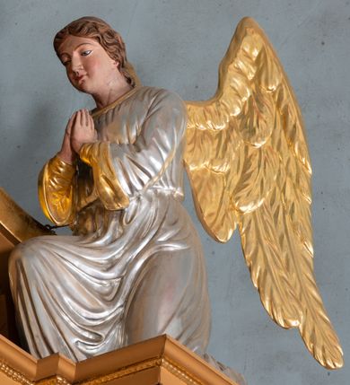 Zdjęcie nr 10: Nastawa ołtarzowa architektoniczna, jednoosiowa, jednokondygnacyjna z bramkami i zwieńczeniem, ustawiona na wysokim, dwustrefowym cokole. Ołtarz prostopadłościenny, murowany, umieszczony w drewnianej obudowie. Antependium ujęte ramą dekorowaną plecionką, podzielone na trzy pola: w środkowym płaskorzeźbione przedstawienie Ostatniej Wieczerzy według Leonarda da Vinci, a po bokach ornament roślinny o wertykalnym układzie.

Tabernakulum architektoniczne, jednokondygnacyjne, trójosiowe, ustawione na zdwojonym na cokole z dwoma zwieńczeniami na osiach skrajnych. Osie wydzielone są parami kolumn o kapitelach kompozytowych, oś środkowa wysunięta do przodu. Podpory dźwigają pełne belkowanie wyłamane na ich linii, przerwane nad polem środkowym, gdzie kolumny dźwigają przerwany półkolisty przyczółek połączony z łukiem gzymsu, nad nim ustawiona jest rzeźba Baranka leżącego na księdze z siedmioma pieczęciami. W polu środkowym dwuskrzydłowe drzwiczki do metalowego tabernakulum ujęte ramą w formie stojącego prostokąta, zamkniętego łukiem nadwieszonym z długim uskokiem. Na drzwiczkach znajdują się dwa aplikowane klęczące anioły, powyżej Chrismo w medalionie, otoczonym glorią. W osiach bocznych są nisze zamknięte konchami z figurkami aniołów, zamknięte zwieńczeniami w formie stojących prostokątów z falistym gzymsem i gałązkami lilii na szczycie; w polu srebrzone, owalne medaliony. Po bokach kondygnacji na wolutowych uszach oraz po bokach zwieńczeń znajdują się wazony ze słonecznikami. Cokół zdobiony jest ornamentem akantowym.

Kondygnacja ujęta jest dwiema parami kolumn o kapitelach kompozytowych oraz stojącą między nimi parą filarów. Podpory dźwigają pełne belkowanie o silnie wysuniętym gzymsie, wyłamane na osiach bocznych, z podwieszonymi szyszkami na tle filarów; przerwane nad polem środkowym. W centrum pole w formie stojącego prostokąta ujęte ramą dekorowaną ornamentem roślinnym z płaskorzeźbionym przedstawieniem Matki Boskiej z Dzieciątkiem. Na zasuwie obrazy: „Najświętsze Serce Pana Jezusa”, „Zwiastowanie” oraz „Św. Mikołaj”. Nad bramkami oraz pomiędzy kolumnami ustawione są rzeźby. Od lewej kolejno: św. Andrzej, św. Wojciech, św. Stanisław i na końcu po prawej św. Tomasz. Nad polem głównym znajduje się przeszklony prześwit w formie półkola z rzeźbioną gołębicą Ducha Świętego na tle glorii. Powyżej pole zamknięte półkoliście fragmentem gzymsu z rzeźbionym popiersiem błogosławiącego Boga Ojca pośród obłoków. Zwieńczenie w formie zbliżonej do stojącego prostokąta o wklęsłych bokach z gzymsem i z podwieszonym lambrekinem oraz kotarami spływającymi na boki. W polu przeszklony prześwit w formie kwadratu zamkniętego łukiem nadwieszonym z rzeźbionym monogramem Marii na tle glorii. Po bokach zwieńczenia ustawione są dwie duże figury klęczących aniołów.

Bramki po bokach ołtarza ustawione są na wysokości cokołu nastawy; przejścia ujęte są parą kanelowanych pilastrów, zamknięte łukiem utworzonym z dwóch przeciwstawnych wolut wspierających wieńczące cokoły. Przejścia w formie wydłużonego stojącego prostokąta zamkniętego łukiem półkolistym nadwieszonym.

Całość ołtarza oprócz tabernakulum dekorowana jest ornamentem małżowinowo-chrząstkowym. Uszy flankujące kondygnację utworzone są również z ornamentu małżowinowo-chrząstkowego. Na zamknięciu zwieńczenia znajdują się dwie uskrzydlone główki anielskie skierowane na wprost z podwieszonymi u szyi chustami. Struktura ołtarza polichromowana jest w kolorze brązowym ze złoconymi kolumnami, ornamentyką i profilami, detale srebrzone.