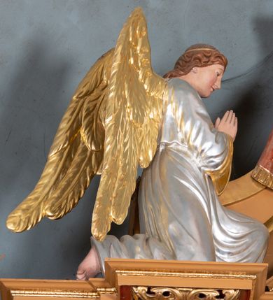 Zdjęcie nr 12: Nastawa ołtarzowa architektoniczna, jednoosiowa, jednokondygnacyjna z bramkami i zwieńczeniem, ustawiona na wysokim, dwustrefowym cokole. Ołtarz prostopadłościenny, murowany, umieszczony w drewnianej obudowie. Antependium ujęte ramą dekorowaną plecionką, podzielone na trzy pola: w środkowym płaskorzeźbione przedstawienie Ostatniej Wieczerzy według Leonarda da Vinci, a po bokach ornament roślinny o wertykalnym układzie.

Tabernakulum architektoniczne, jednokondygnacyjne, trójosiowe, ustawione na zdwojonym na cokole z dwoma zwieńczeniami na osiach skrajnych. Osie wydzielone są parami kolumn o kapitelach kompozytowych, oś środkowa wysunięta do przodu. Podpory dźwigają pełne belkowanie wyłamane na ich linii, przerwane nad polem środkowym, gdzie kolumny dźwigają przerwany półkolisty przyczółek połączony z łukiem gzymsu, nad nim ustawiona jest rzeźba Baranka leżącego na księdze z siedmioma pieczęciami. W polu środkowym dwuskrzydłowe drzwiczki do metalowego tabernakulum ujęte ramą w formie stojącego prostokąta, zamkniętego łukiem nadwieszonym z długim uskokiem. Na drzwiczkach znajdują się dwa aplikowane klęczące anioły, powyżej Chrismo w medalionie, otoczonym glorią. W osiach bocznych są nisze zamknięte konchami z figurkami aniołów, zamknięte zwieńczeniami w formie stojących prostokątów z falistym gzymsem i gałązkami lilii na szczycie; w polu srebrzone, owalne medaliony. Po bokach kondygnacji na wolutowych uszach oraz po bokach zwieńczeń znajdują się wazony ze słonecznikami. Cokół zdobiony jest ornamentem akantowym.

Kondygnacja ujęta jest dwiema parami kolumn o kapitelach kompozytowych oraz stojącą między nimi parą filarów. Podpory dźwigają pełne belkowanie o silnie wysuniętym gzymsie, wyłamane na osiach bocznych, z podwieszonymi szyszkami na tle filarów; przerwane nad polem środkowym. W centrum pole w formie stojącego prostokąta ujęte ramą dekorowaną ornamentem roślinnym z płaskorzeźbionym przedstawieniem Matki Boskiej z Dzieciątkiem. Na zasuwie obrazy: „Najświętsze Serce Pana Jezusa”, „Zwiastowanie” oraz „Św. Mikołaj”. Nad bramkami oraz pomiędzy kolumnami ustawione są rzeźby. Od lewej kolejno: św. Andrzej, św. Wojciech, św. Stanisław i na końcu po prawej św. Tomasz. Nad polem głównym znajduje się przeszklony prześwit w formie półkola z rzeźbioną gołębicą Ducha Świętego na tle glorii. Powyżej pole zamknięte półkoliście fragmentem gzymsu z rzeźbionym popiersiem błogosławiącego Boga Ojca pośród obłoków. Zwieńczenie w formie zbliżonej do stojącego prostokąta o wklęsłych bokach z gzymsem i z podwieszonym lambrekinem oraz kotarami spływającymi na boki. W polu przeszklony prześwit w formie kwadratu zamkniętego łukiem nadwieszonym z rzeźbionym monogramem Marii na tle glorii. Po bokach zwieńczenia ustawione są dwie duże figury klęczących aniołów.

Bramki po bokach ołtarza ustawione są na wysokości cokołu nastawy; przejścia ujęte są parą kanelowanych pilastrów, zamknięte łukiem utworzonym z dwóch przeciwstawnych wolut wspierających wieńczące cokoły. Przejścia w formie wydłużonego stojącego prostokąta zamkniętego łukiem półkolistym nadwieszonym.

Całość ołtarza oprócz tabernakulum dekorowana jest ornamentem małżowinowo-chrząstkowym. Uszy flankujące kondygnację utworzone są również z ornamentu małżowinowo-chrząstkowego. Na zamknięciu zwieńczenia znajdują się dwie uskrzydlone główki anielskie skierowane na wprost z podwieszonymi u szyi chustami. Struktura ołtarza polichromowana jest w kolorze brązowym ze złoconymi kolumnami, ornamentyką i profilami, detale srebrzone.