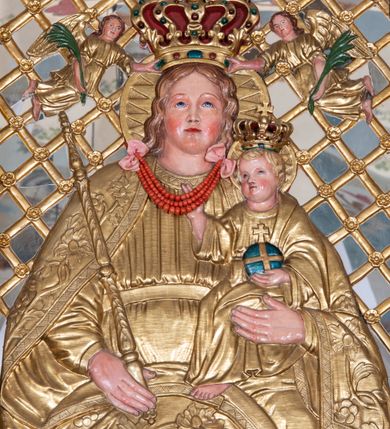 Zdjęcie nr 33: Nastawa ołtarzowa architektoniczna, jednoosiowa, jednokondygnacyjna z bramkami i zwieńczeniem, ustawiona na wysokim, dwustrefowym cokole. Ołtarz prostopadłościenny, murowany, umieszczony w drewnianej obudowie. Antependium ujęte ramą dekorowaną plecionką, podzielone na trzy pola: w środkowym płaskorzeźbione przedstawienie Ostatniej Wieczerzy według Leonarda da Vinci, a po bokach ornament roślinny o wertykalnym układzie.

Tabernakulum architektoniczne, jednokondygnacyjne, trójosiowe, ustawione na zdwojonym na cokole z dwoma zwieńczeniami na osiach skrajnych. Osie wydzielone są parami kolumn o kapitelach kompozytowych, oś środkowa wysunięta do przodu. Podpory dźwigają pełne belkowanie wyłamane na ich linii, przerwane nad polem środkowym, gdzie kolumny dźwigają przerwany półkolisty przyczółek połączony z łukiem gzymsu, nad nim ustawiona jest rzeźba Baranka leżącego na księdze z siedmioma pieczęciami. W polu środkowym dwuskrzydłowe drzwiczki do metalowego tabernakulum ujęte ramą w formie stojącego prostokąta, zamkniętego łukiem nadwieszonym z długim uskokiem. Na drzwiczkach znajdują się dwa aplikowane klęczące anioły, powyżej Chrismo w medalionie, otoczonym glorią. W osiach bocznych są nisze zamknięte konchami z figurkami aniołów, zamknięte zwieńczeniami w formie stojących prostokątów z falistym gzymsem i gałązkami lilii na szczycie; w polu srebrzone, owalne medaliony. Po bokach kondygnacji na wolutowych uszach oraz po bokach zwieńczeń znajdują się wazony ze słonecznikami. Cokół zdobiony jest ornamentem akantowym.

Kondygnacja ujęta jest dwiema parami kolumn o kapitelach kompozytowych oraz stojącą między nimi parą filarów. Podpory dźwigają pełne belkowanie o silnie wysuniętym gzymsie, wyłamane na osiach bocznych, z podwieszonymi szyszkami na tle filarów; przerwane nad polem środkowym. W centrum pole w formie stojącego prostokąta ujęte ramą dekorowaną ornamentem roślinnym z płaskorzeźbionym przedstawieniem Matki Boskiej z Dzieciątkiem. Na zasuwie obrazy: „Najświętsze Serce Pana Jezusa”, „Zwiastowanie” oraz „Św. Mikołaj”. Nad bramkami oraz pomiędzy kolumnami ustawione są rzeźby. Od lewej kolejno: św. Andrzej, św. Wojciech, św. Stanisław i na końcu po prawej św. Tomasz. Nad polem głównym znajduje się przeszklony prześwit w formie półkola z rzeźbioną gołębicą Ducha Świętego na tle glorii. Powyżej pole zamknięte półkoliście fragmentem gzymsu z rzeźbionym popiersiem błogosławiącego Boga Ojca pośród obłoków. Zwieńczenie w formie zbliżonej do stojącego prostokąta o wklęsłych bokach z gzymsem i z podwieszonym lambrekinem oraz kotarami spływającymi na boki. W polu przeszklony prześwit w formie kwadratu zamkniętego łukiem nadwieszonym z rzeźbionym monogramem Marii na tle glorii. Po bokach zwieńczenia ustawione są dwie duże figury klęczących aniołów.

Bramki po bokach ołtarza ustawione są na wysokości cokołu nastawy; przejścia ujęte są parą kanelowanych pilastrów, zamknięte łukiem utworzonym z dwóch przeciwstawnych wolut wspierających wieńczące cokoły. Przejścia w formie wydłużonego stojącego prostokąta zamkniętego łukiem półkolistym nadwieszonym.

Całość ołtarza oprócz tabernakulum dekorowana jest ornamentem małżowinowo-chrząstkowym. Uszy flankujące kondygnację utworzone są również z ornamentu małżowinowo-chrząstkowego. Na zamknięciu zwieńczenia znajdują się dwie uskrzydlone główki anielskie skierowane na wprost z podwieszonymi u szyi chustami. Struktura ołtarza polichromowana jest w kolorze brązowym ze złoconymi kolumnami, ornamentyką i profilami, detale srebrzone.