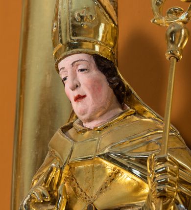 Zdjęcie nr 46: Nastawa ołtarzowa architektoniczna, jednoosiowa, jednokondygnacyjna z bramkami i zwieńczeniem, ustawiona na wysokim, dwustrefowym cokole. Ołtarz prostopadłościenny, murowany, umieszczony w drewnianej obudowie. Antependium ujęte ramą dekorowaną plecionką, podzielone na trzy pola: w środkowym płaskorzeźbione przedstawienie Ostatniej Wieczerzy według Leonarda da Vinci, a po bokach ornament roślinny o wertykalnym układzie.

Tabernakulum architektoniczne, jednokondygnacyjne, trójosiowe, ustawione na zdwojonym na cokole z dwoma zwieńczeniami na osiach skrajnych. Osie wydzielone są parami kolumn o kapitelach kompozytowych, oś środkowa wysunięta do przodu. Podpory dźwigają pełne belkowanie wyłamane na ich linii, przerwane nad polem środkowym, gdzie kolumny dźwigają przerwany półkolisty przyczółek połączony z łukiem gzymsu, nad nim ustawiona jest rzeźba Baranka leżącego na księdze z siedmioma pieczęciami. W polu środkowym dwuskrzydłowe drzwiczki do metalowego tabernakulum ujęte ramą w formie stojącego prostokąta, zamkniętego łukiem nadwieszonym z długim uskokiem. Na drzwiczkach znajdują się dwa aplikowane klęczące anioły, powyżej Chrismo w medalionie, otoczonym glorią. W osiach bocznych są nisze zamknięte konchami z figurkami aniołów, zamknięte zwieńczeniami w formie stojących prostokątów z falistym gzymsem i gałązkami lilii na szczycie; w polu srebrzone, owalne medaliony. Po bokach kondygnacji na wolutowych uszach oraz po bokach zwieńczeń znajdują się wazony ze słonecznikami. Cokół zdobiony jest ornamentem akantowym.

Kondygnacja ujęta jest dwiema parami kolumn o kapitelach kompozytowych oraz stojącą między nimi parą filarów. Podpory dźwigają pełne belkowanie o silnie wysuniętym gzymsie, wyłamane na osiach bocznych, z podwieszonymi szyszkami na tle filarów; przerwane nad polem środkowym. W centrum pole w formie stojącego prostokąta ujęte ramą dekorowaną ornamentem roślinnym z płaskorzeźbionym przedstawieniem Matki Boskiej z Dzieciątkiem. Na zasuwie obrazy: „Najświętsze Serce Pana Jezusa”, „Zwiastowanie” oraz „Św. Mikołaj”. Nad bramkami oraz pomiędzy kolumnami ustawione są rzeźby. Od lewej kolejno: św. Andrzej, św. Wojciech, św. Stanisław i na końcu po prawej św. Tomasz. Nad polem głównym znajduje się przeszklony prześwit w formie półkola z rzeźbioną gołębicą Ducha Świętego na tle glorii. Powyżej pole zamknięte półkoliście fragmentem gzymsu z rzeźbionym popiersiem błogosławiącego Boga Ojca pośród obłoków. Zwieńczenie w formie zbliżonej do stojącego prostokąta o wklęsłych bokach z gzymsem i z podwieszonym lambrekinem oraz kotarami spływającymi na boki. W polu przeszklony prześwit w formie kwadratu zamkniętego łukiem nadwieszonym z rzeźbionym monogramem Marii na tle glorii. Po bokach zwieńczenia ustawione są dwie duże figury klęczących aniołów.

Bramki po bokach ołtarza ustawione są na wysokości cokołu nastawy; przejścia ujęte są parą kanelowanych pilastrów, zamknięte łukiem utworzonym z dwóch przeciwstawnych wolut wspierających wieńczące cokoły. Przejścia w formie wydłużonego stojącego prostokąta zamkniętego łukiem półkolistym nadwieszonym.

Całość ołtarza oprócz tabernakulum dekorowana jest ornamentem małżowinowo-chrząstkowym. Uszy flankujące kondygnację utworzone są również z ornamentu małżowinowo-chrząstkowego. Na zamknięciu zwieńczenia znajdują się dwie uskrzydlone główki anielskie skierowane na wprost z podwieszonymi u szyi chustami. Struktura ołtarza polichromowana jest w kolorze brązowym ze złoconymi kolumnami, ornamentyką i profilami, detale srebrzone.