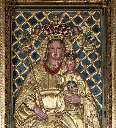 Zdjęcie nr 35: Nastawa ołtarzowa architektoniczna, jednoosiowa, jednokondygnacyjna z bramkami i zwieńczeniem, ustawiona na wysokim, dwustrefowym cokole. Ołtarz prostopadłościenny, murowany, umieszczony w drewnianej obudowie. Antependium ujęte ramą dekorowaną plecionką, podzielone na trzy pola: w środkowym płaskorzeźbione przedstawienie Ostatniej Wieczerzy według Leonarda da Vinci, a po bokach ornament roślinny o wertykalnym układzie.

Tabernakulum architektoniczne, jednokondygnacyjne, trójosiowe, ustawione na zdwojonym na cokole z dwoma zwieńczeniami na osiach skrajnych. Osie wydzielone są parami kolumn o kapitelach kompozytowych, oś środkowa wysunięta do przodu. Podpory dźwigają pełne belkowanie wyłamane na ich linii, przerwane nad polem środkowym, gdzie kolumny dźwigają przerwany półkolisty przyczółek połączony z łukiem gzymsu, nad nim ustawiona jest rzeźba Baranka leżącego na księdze z siedmioma pieczęciami. W polu środkowym dwuskrzydłowe drzwiczki do metalowego tabernakulum ujęte ramą w formie stojącego prostokąta, zamkniętego łukiem nadwieszonym z długim uskokiem. Na drzwiczkach znajdują się dwa aplikowane klęczące anioły, powyżej Chrismo w medalionie, otoczonym glorią. W osiach bocznych są nisze zamknięte konchami z figurkami aniołów, zamknięte zwieńczeniami w formie stojących prostokątów z falistym gzymsem i gałązkami lilii na szczycie; w polu srebrzone, owalne medaliony. Po bokach kondygnacji na wolutowych uszach oraz po bokach zwieńczeń znajdują się wazony ze słonecznikami. Cokół zdobiony jest ornamentem akantowym.

Kondygnacja ujęta jest dwiema parami kolumn o kapitelach kompozytowych oraz stojącą między nimi parą filarów. Podpory dźwigają pełne belkowanie o silnie wysuniętym gzymsie, wyłamane na osiach bocznych, z podwieszonymi szyszkami na tle filarów; przerwane nad polem środkowym. W centrum pole w formie stojącego prostokąta ujęte ramą dekorowaną ornamentem roślinnym z płaskorzeźbionym przedstawieniem Matki Boskiej z Dzieciątkiem. Na zasuwie obrazy: „Najświętsze Serce Pana Jezusa”, „Zwiastowanie” oraz „Św. Mikołaj”. Nad bramkami oraz pomiędzy kolumnami ustawione są rzeźby. Od lewej kolejno: św. Andrzej, św. Wojciech, św. Stanisław i na końcu po prawej św. Tomasz. Nad polem głównym znajduje się przeszklony prześwit w formie półkola z rzeźbioną gołębicą Ducha Świętego na tle glorii. Powyżej pole zamknięte półkoliście fragmentem gzymsu z rzeźbionym popiersiem błogosławiącego Boga Ojca pośród obłoków. Zwieńczenie w formie zbliżonej do stojącego prostokąta o wklęsłych bokach z gzymsem i z podwieszonym lambrekinem oraz kotarami spływającymi na boki. W polu przeszklony prześwit w formie kwadratu zamkniętego łukiem nadwieszonym z rzeźbionym monogramem Marii na tle glorii. Po bokach zwieńczenia ustawione są dwie duże figury klęczących aniołów.

Bramki po bokach ołtarza ustawione są na wysokości cokołu nastawy; przejścia ujęte są parą kanelowanych pilastrów, zamknięte łukiem utworzonym z dwóch przeciwstawnych wolut wspierających wieńczące cokoły. Przejścia w formie wydłużonego stojącego prostokąta zamkniętego łukiem półkolistym nadwieszonym.

Całość ołtarza oprócz tabernakulum dekorowana jest ornamentem małżowinowo-chrząstkowym. Uszy flankujące kondygnację utworzone są również z ornamentu małżowinowo-chrząstkowego. Na zamknięciu zwieńczenia znajdują się dwie uskrzydlone główki anielskie skierowane na wprost z podwieszonymi u szyi chustami. Struktura ołtarza polichromowana jest w kolorze brązowym ze złoconymi kolumnami, ornamentyką i profilami, detale srebrzone.