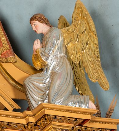 Zdjęcie nr 57: Nastawa ołtarzowa architektoniczna, jednoosiowa, jednokondygnacyjna z bramkami i zwieńczeniem, ustawiona na wysokim, dwustrefowym cokole. Ołtarz prostopadłościenny, murowany, umieszczony w drewnianej obudowie. Antependium ujęte ramą dekorowaną plecionką, podzielone na trzy pola: w środkowym płaskorzeźbione przedstawienie Ostatniej Wieczerzy według Leonarda da Vinci, a po bokach ornament roślinny o wertykalnym układzie.

Tabernakulum architektoniczne, jednokondygnacyjne, trójosiowe, ustawione na zdwojonym na cokole z dwoma zwieńczeniami na osiach skrajnych. Osie wydzielone są parami kolumn o kapitelach kompozytowych, oś środkowa wysunięta do przodu. Podpory dźwigają pełne belkowanie wyłamane na ich linii, przerwane nad polem środkowym, gdzie kolumny dźwigają przerwany półkolisty przyczółek połączony z łukiem gzymsu, nad nim ustawiona jest rzeźba Baranka leżącego na księdze z siedmioma pieczęciami. W polu środkowym dwuskrzydłowe drzwiczki do metalowego tabernakulum ujęte ramą w formie stojącego prostokąta, zamkniętego łukiem nadwieszonym z długim uskokiem. Na drzwiczkach znajdują się dwa aplikowane klęczące anioły, powyżej Chrismo w medalionie, otoczonym glorią. W osiach bocznych są nisze zamknięte konchami z figurkami aniołów, zamknięte zwieńczeniami w formie stojących prostokątów z falistym gzymsem i gałązkami lilii na szczycie; w polu srebrzone, owalne medaliony. Po bokach kondygnacji na wolutowych uszach oraz po bokach zwieńczeń znajdują się wazony ze słonecznikami. Cokół zdobiony jest ornamentem akantowym.

Kondygnacja ujęta jest dwiema parami kolumn o kapitelach kompozytowych oraz stojącą między nimi parą filarów. Podpory dźwigają pełne belkowanie o silnie wysuniętym gzymsie, wyłamane na osiach bocznych, z podwieszonymi szyszkami na tle filarów; przerwane nad polem środkowym. W centrum pole w formie stojącego prostokąta ujęte ramą dekorowaną ornamentem roślinnym z płaskorzeźbionym przedstawieniem Matki Boskiej z Dzieciątkiem. Na zasuwie obrazy: „Najświętsze Serce Pana Jezusa”, „Zwiastowanie” oraz „Św. Mikołaj”. Nad bramkami oraz pomiędzy kolumnami ustawione są rzeźby. Od lewej kolejno: św. Andrzej, św. Wojciech, św. Stanisław i na końcu po prawej św. Tomasz. Nad polem głównym znajduje się przeszklony prześwit w formie półkola z rzeźbioną gołębicą Ducha Świętego na tle glorii. Powyżej pole zamknięte półkoliście fragmentem gzymsu z rzeźbionym popiersiem błogosławiącego Boga Ojca pośród obłoków. Zwieńczenie w formie zbliżonej do stojącego prostokąta o wklęsłych bokach z gzymsem i z podwieszonym lambrekinem oraz kotarami spływającymi na boki. W polu przeszklony prześwit w formie kwadratu zamkniętego łukiem nadwieszonym z rzeźbionym monogramem Marii na tle glorii. Po bokach zwieńczenia ustawione są dwie duże figury klęczących aniołów.

Bramki po bokach ołtarza ustawione są na wysokości cokołu nastawy; przejścia ujęte są parą kanelowanych pilastrów, zamknięte łukiem utworzonym z dwóch przeciwstawnych wolut wspierających wieńczące cokoły. Przejścia w formie wydłużonego stojącego prostokąta zamkniętego łukiem półkolistym nadwieszonym.

Całość ołtarza oprócz tabernakulum dekorowana jest ornamentem małżowinowo-chrząstkowym. Uszy flankujące kondygnację utworzone są również z ornamentu małżowinowo-chrząstkowego. Na zamknięciu zwieńczenia znajdują się dwie uskrzydlone główki anielskie skierowane na wprost z podwieszonymi u szyi chustami. Struktura ołtarza polichromowana jest w kolorze brązowym ze złoconymi kolumnami, ornamentyką i profilami, detale srebrzone.